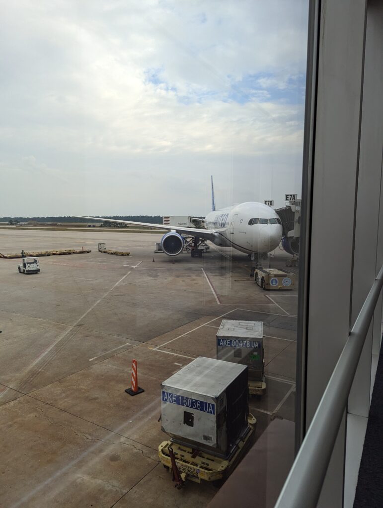 View of the airport tarmac from the United Club at IAH, with United aircraft and ground operations visible through floor-to-ceiling windows.