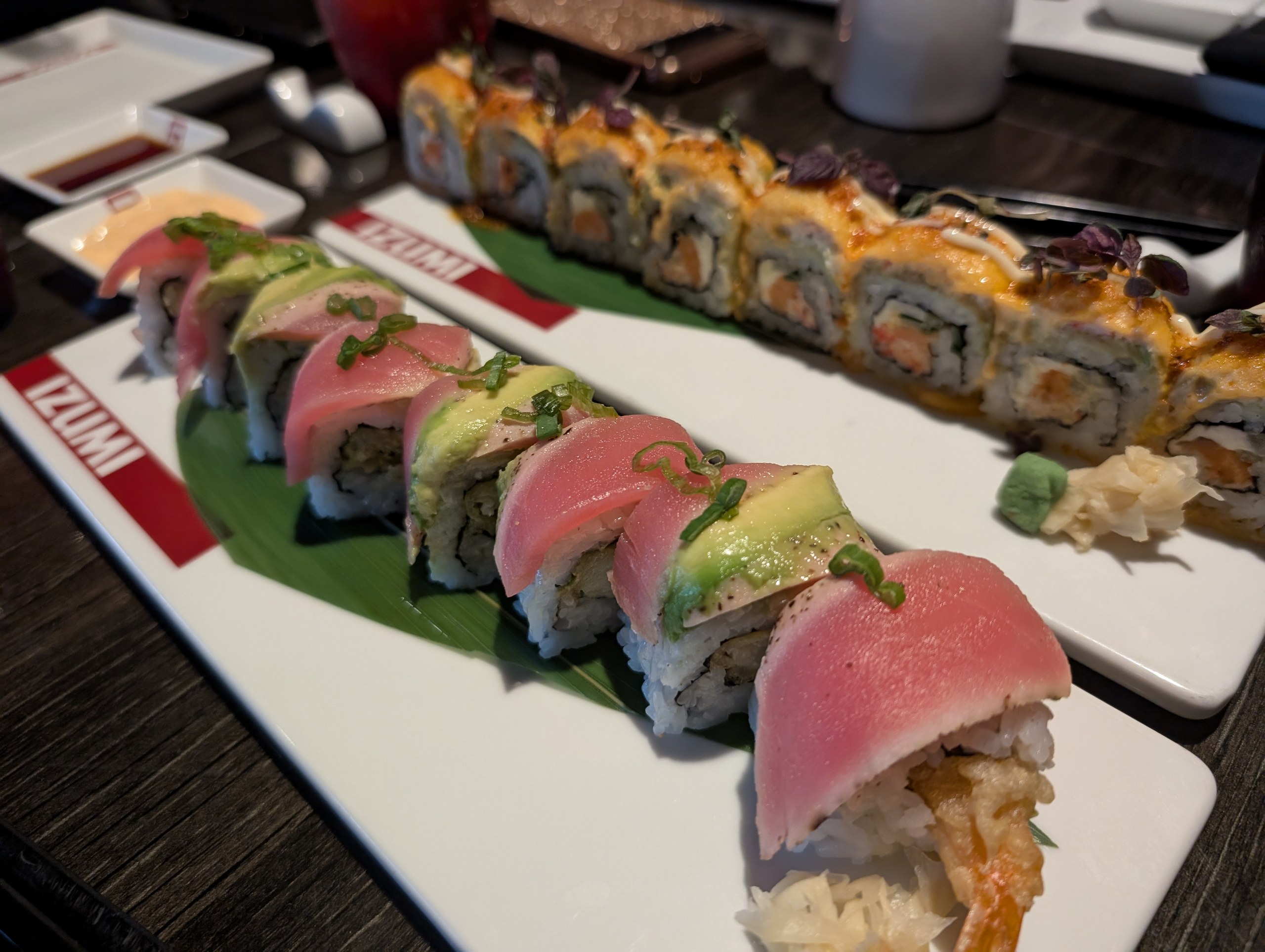 Two specialty sushi rolls topped with tuna, avocado, and scallions on the Izumi-branded plates aboard Harmony of the Seas.