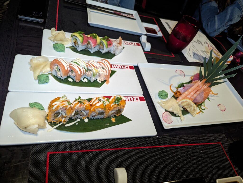 Three sushi-roll plates on Izumi-branded mats with a side of sashimi at the Izumi specialty restaurant on Symphony of the Seas.
