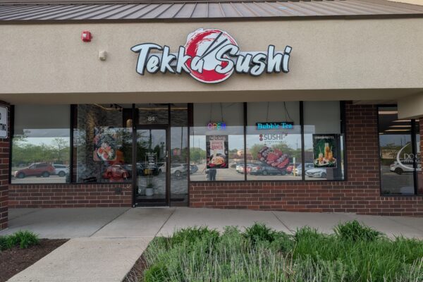Tekka Sushi storefront with bold red and white sign, located in a strip mall in Elk Grove Village, Illinois