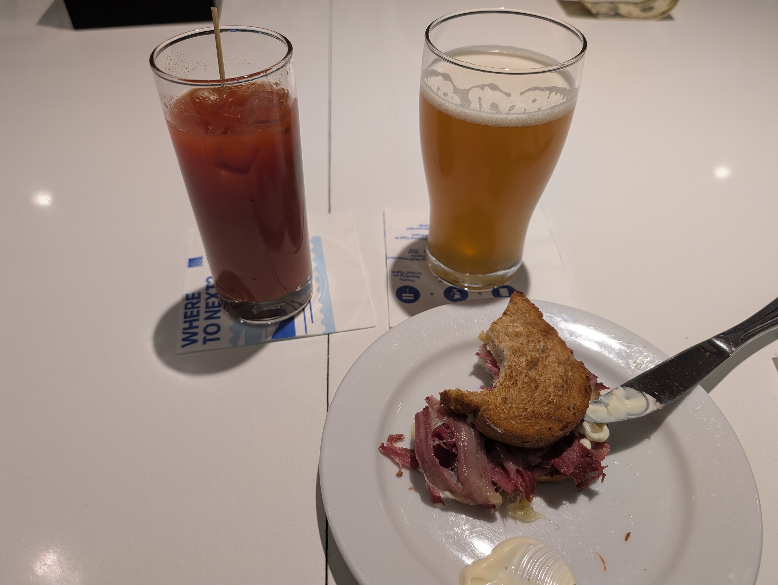 A Reuben on rye next to a bloody mary and a wheat beer at the United Club Newark