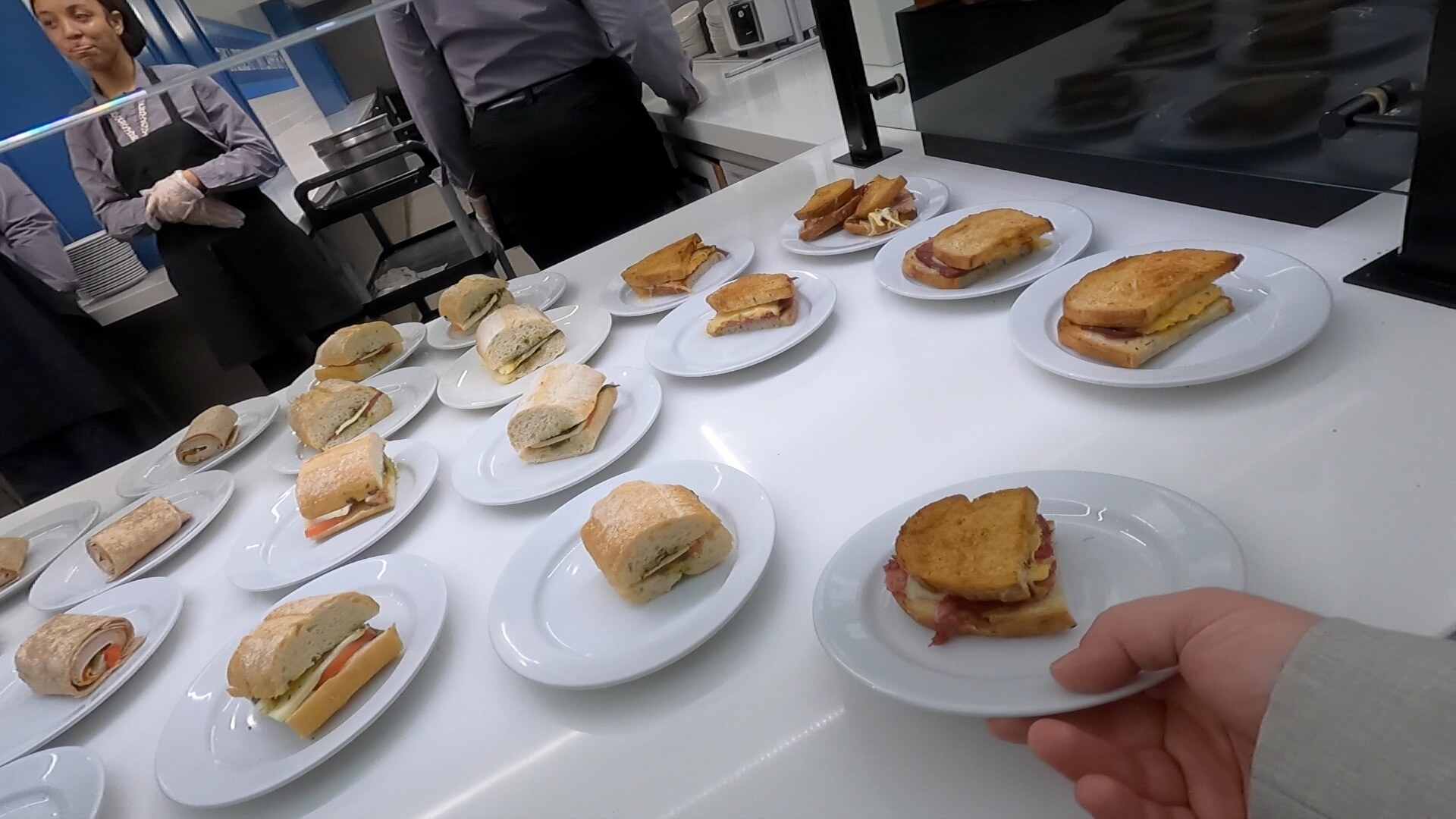 Buffet of mini sandwiches, wraps, and paninis individually plated at the United Club Newark