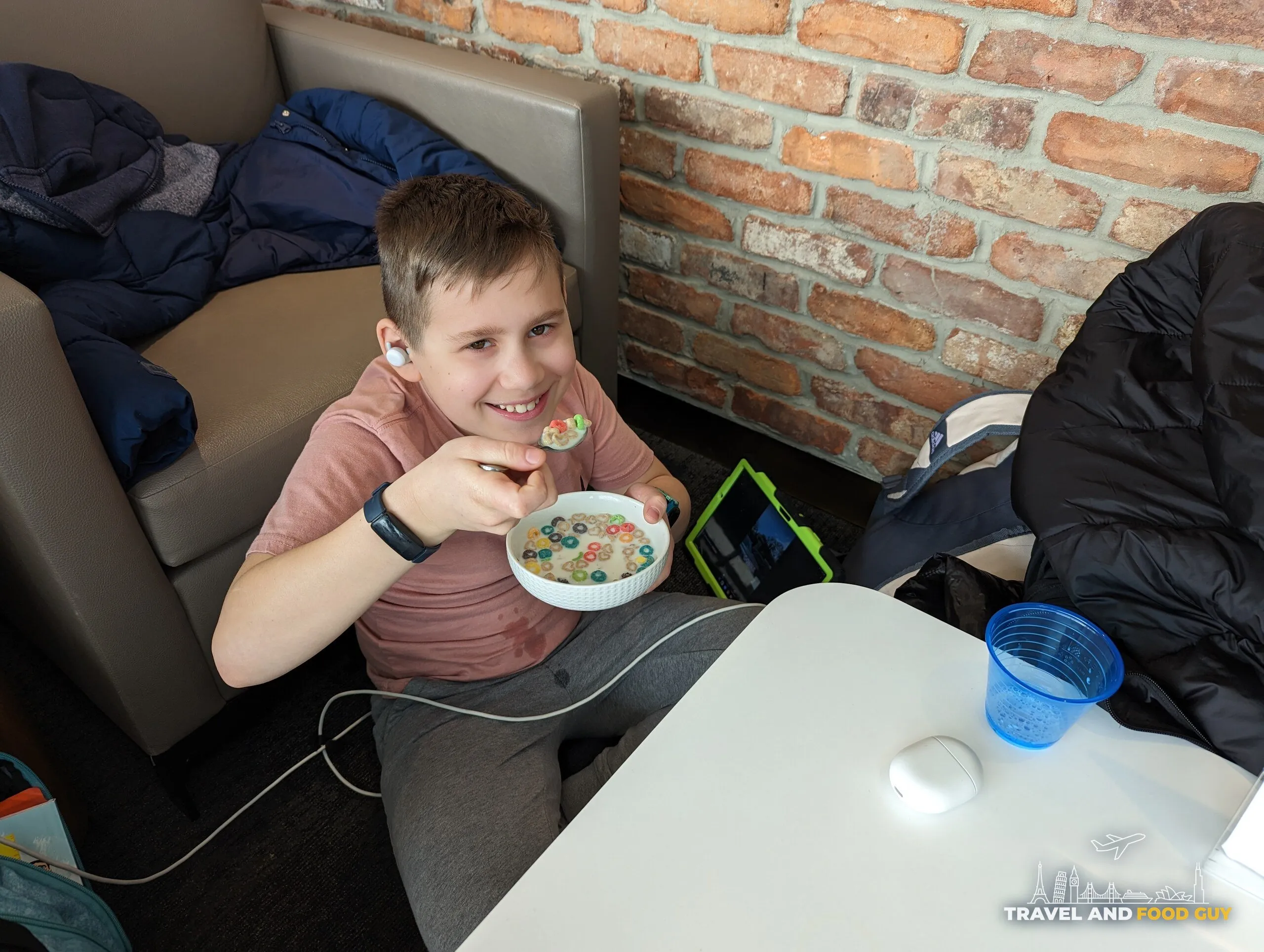 Josh smiling over a bowl of Froot Loops at the cereal bar inside the United Club at Newark Terminal C during a long delay