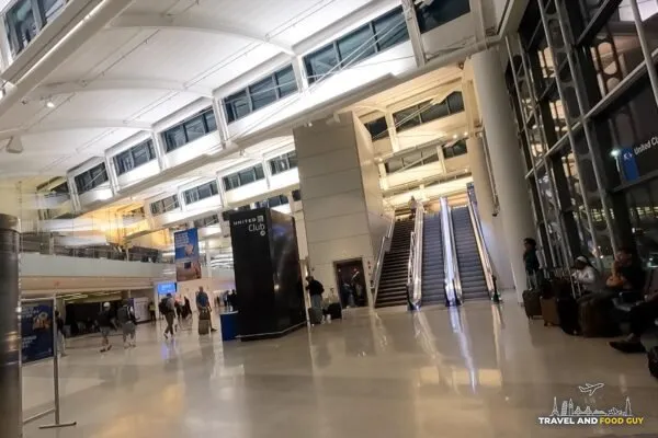The atrium and escalator leading up to the United Club at Newark Terminal C by Gate C123, with the United Club tower sign overhead