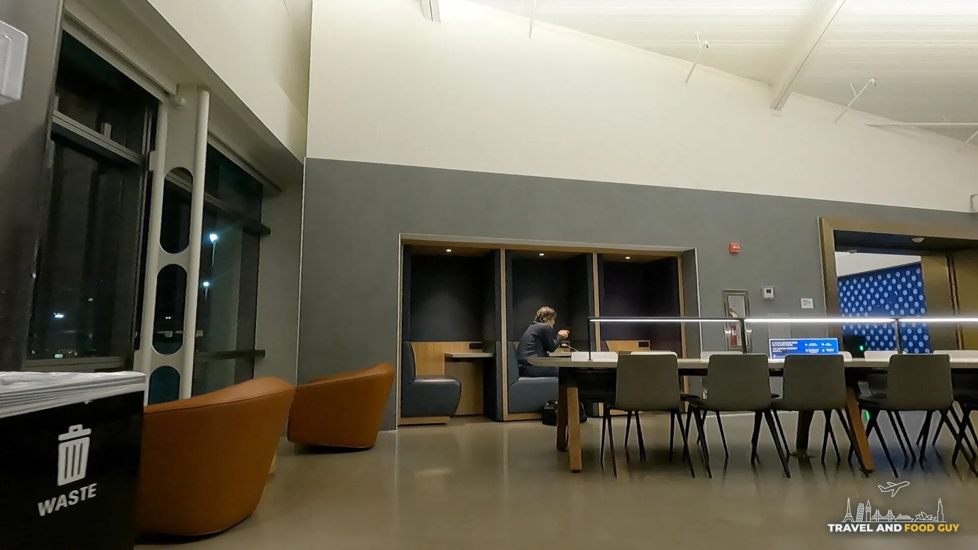 Private work pods next to a long communal table inside the United Club at Newark Terminal C Gate C123