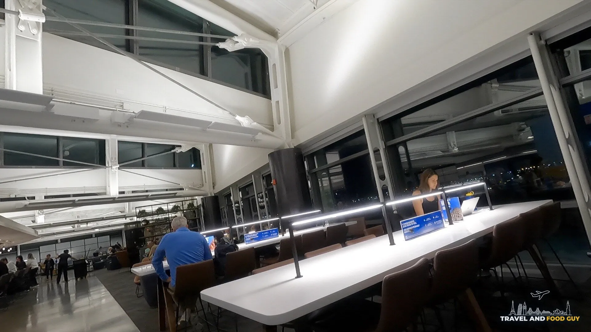 Long workspace counter at the United Club Newark Gate C123 with task lamps and a view of the night tarmac