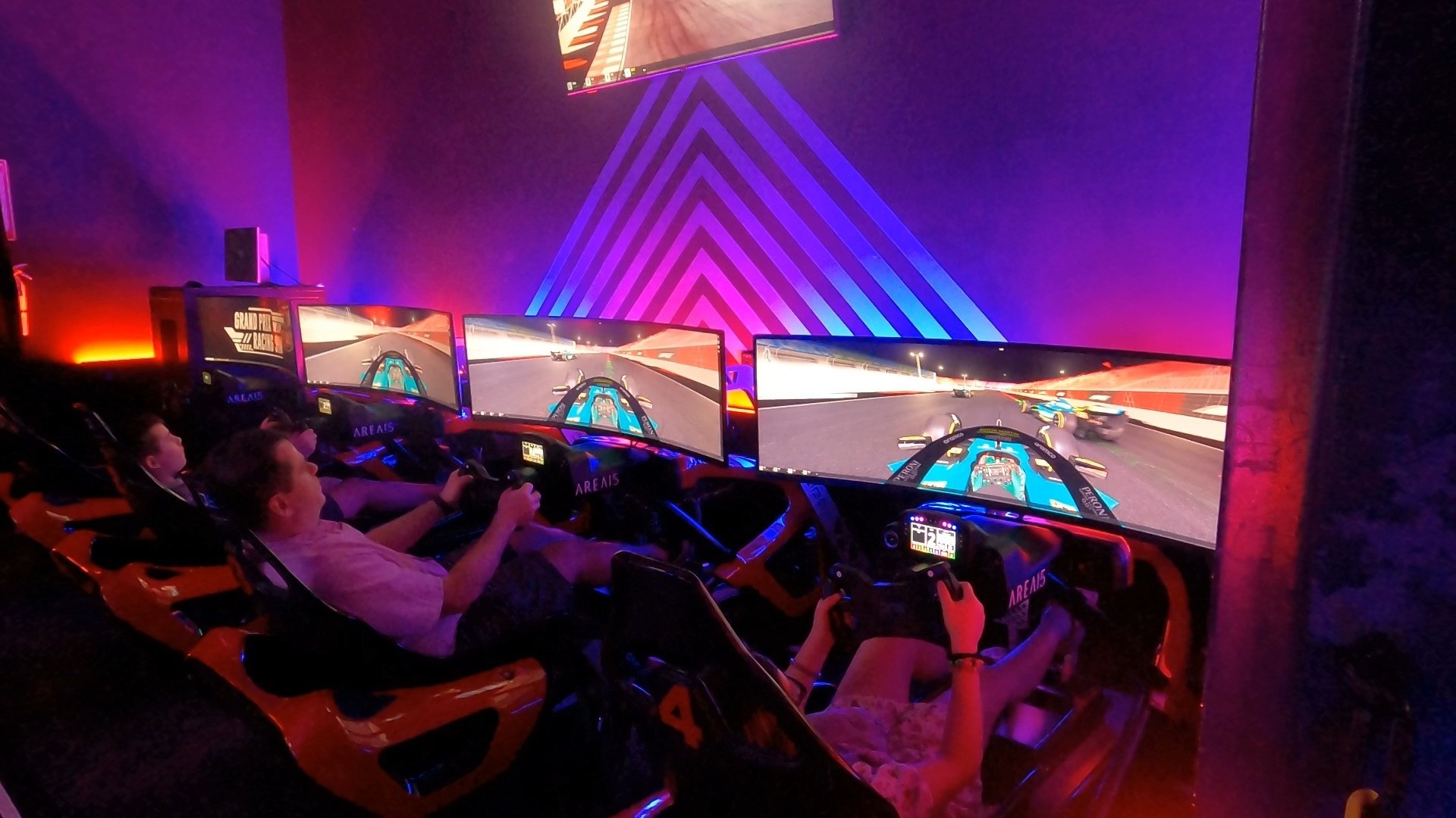 Grand Prix Racing Sim cockpits at Area 15 with riders behind the wheel and triple wraparound screens