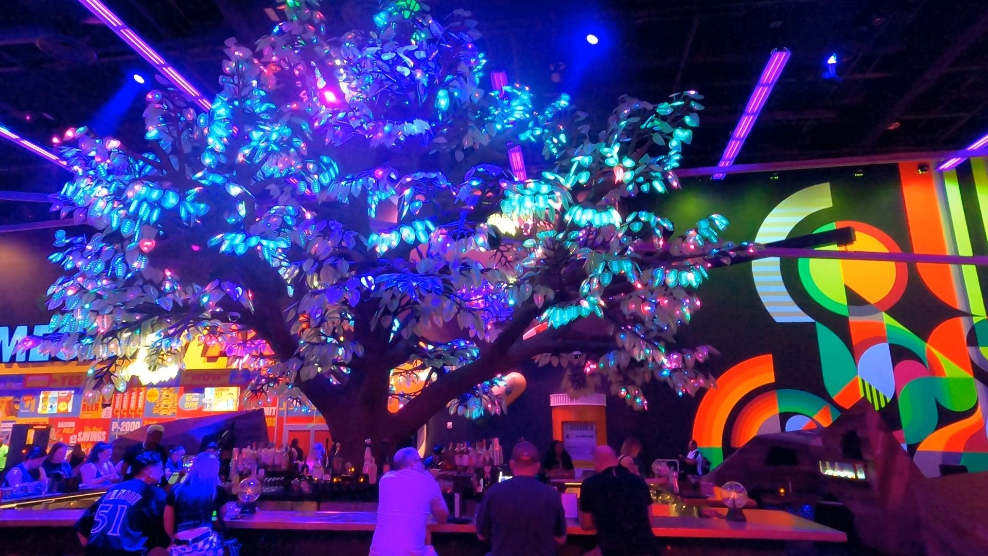 The illuminated tree centerpiece at the Oddwood Tavern inside Area 15 lit up in blue and pink