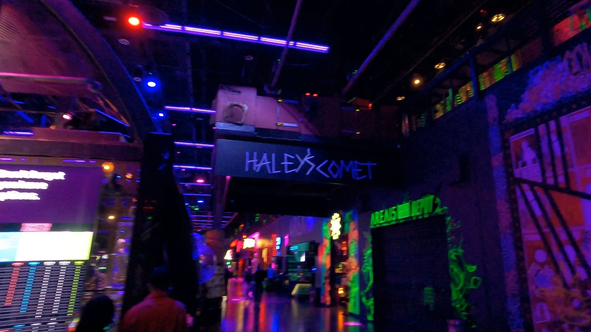 Neon-lit main concourse inside Area 15 in Las Vegas with the Halleys Comet zip line track overhead