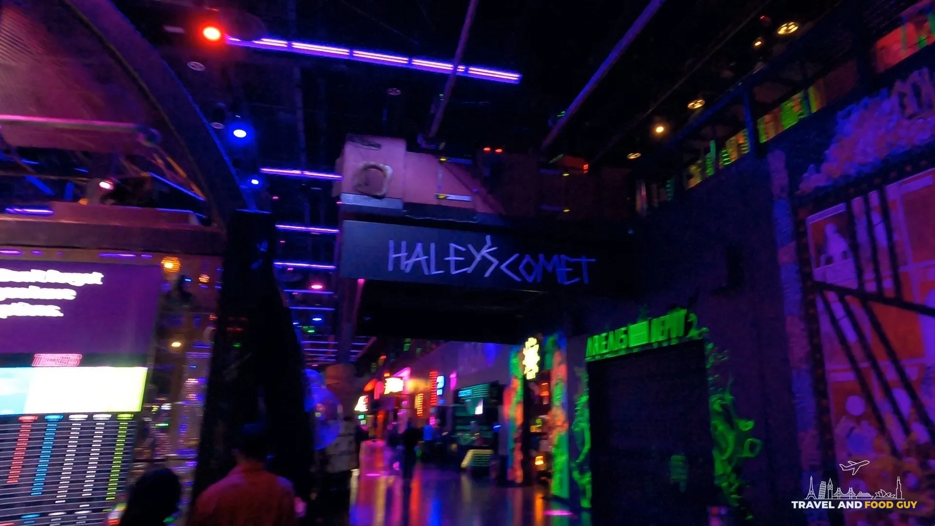 Neon-lit main concourse inside Area 15 in Las Vegas with the Halleys Comet zip line track overhead