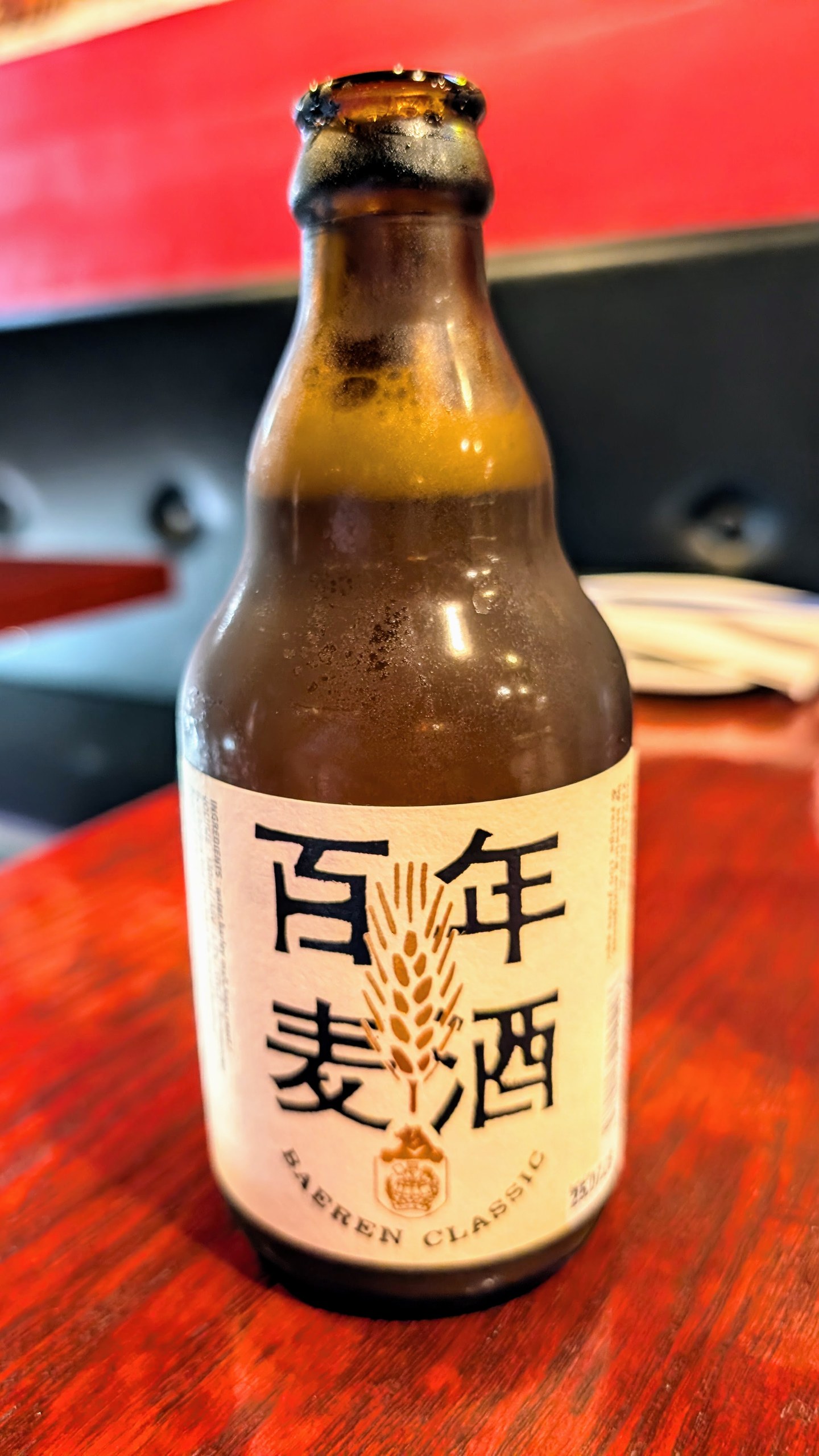Bottle of Baeren Classic Japanese craft beer on a red lacquered table at Ari Sushi