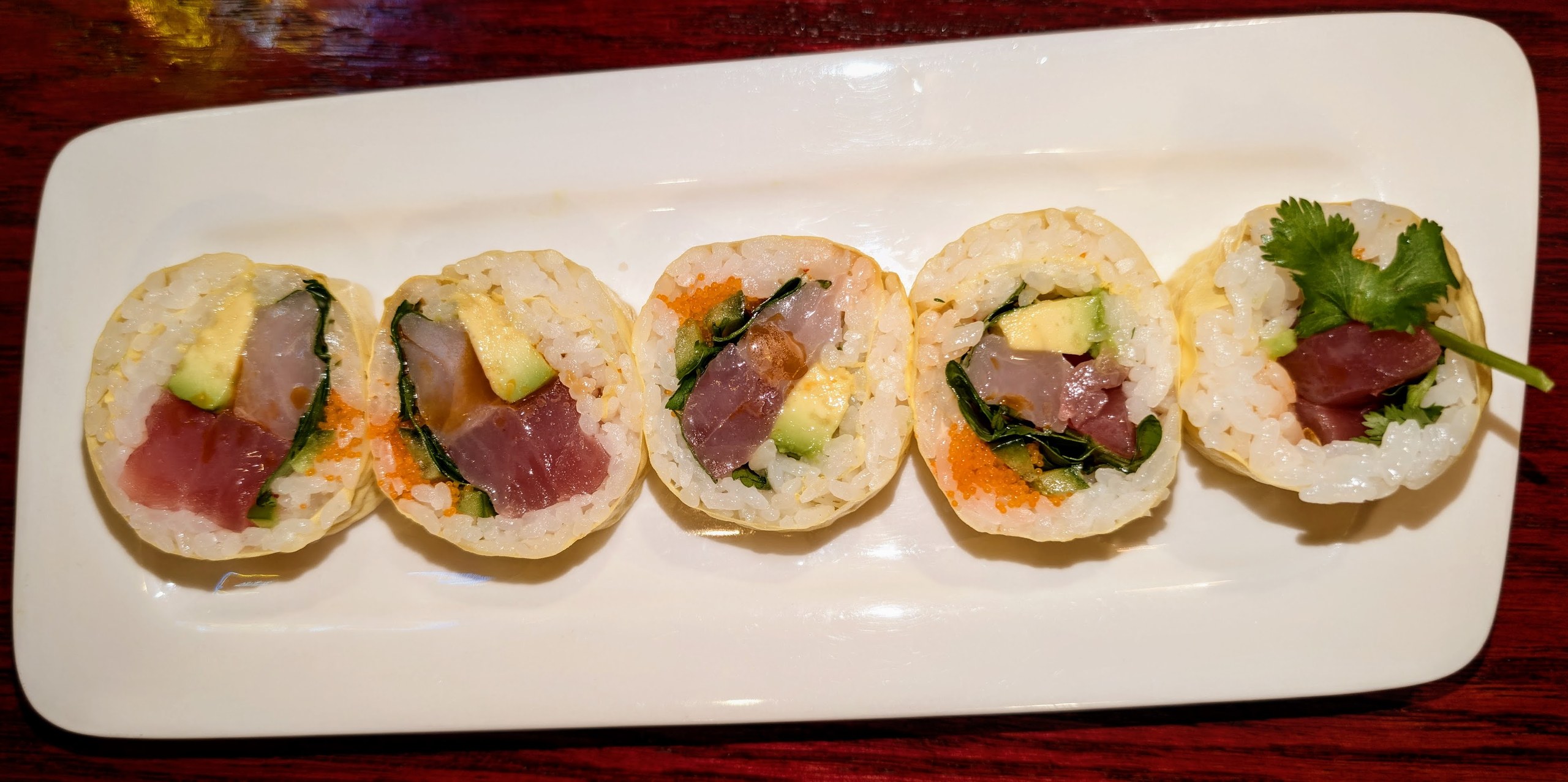 Half Ocean Drive roll at Ari Sushi, fish-forward with thin pink tuna belly and avocado visible inside