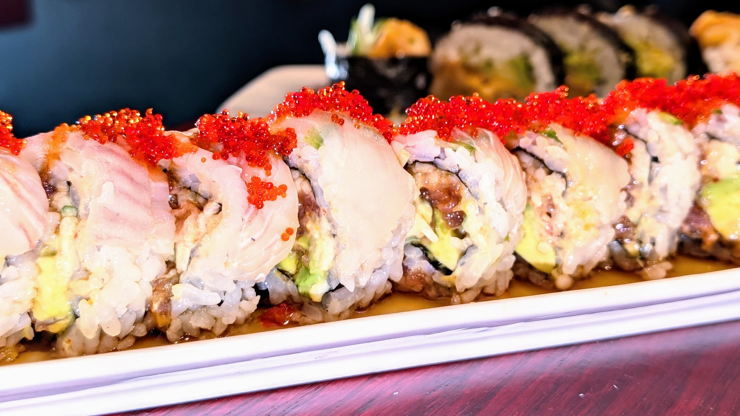 Wide plate of Ari Sushi specialty rolls including the Spicy Tataki, Fire Bird, and others, cut and laid out side by side