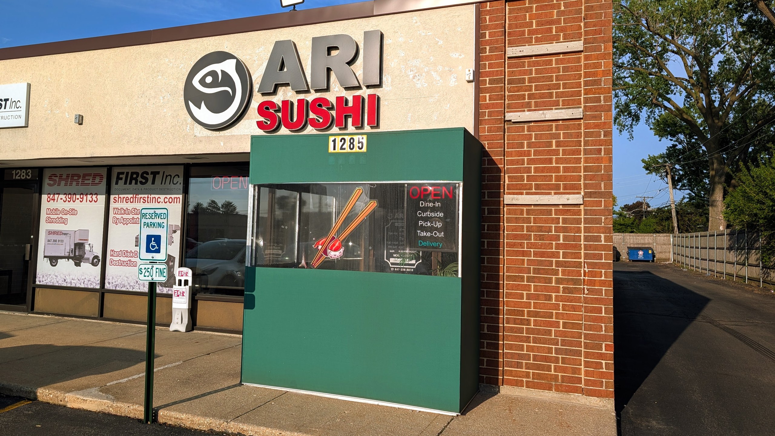 Ari Sushi storefront on Elmhurst Road in Des Plaines, stylized fish logo and red SUSHI text above the entrance