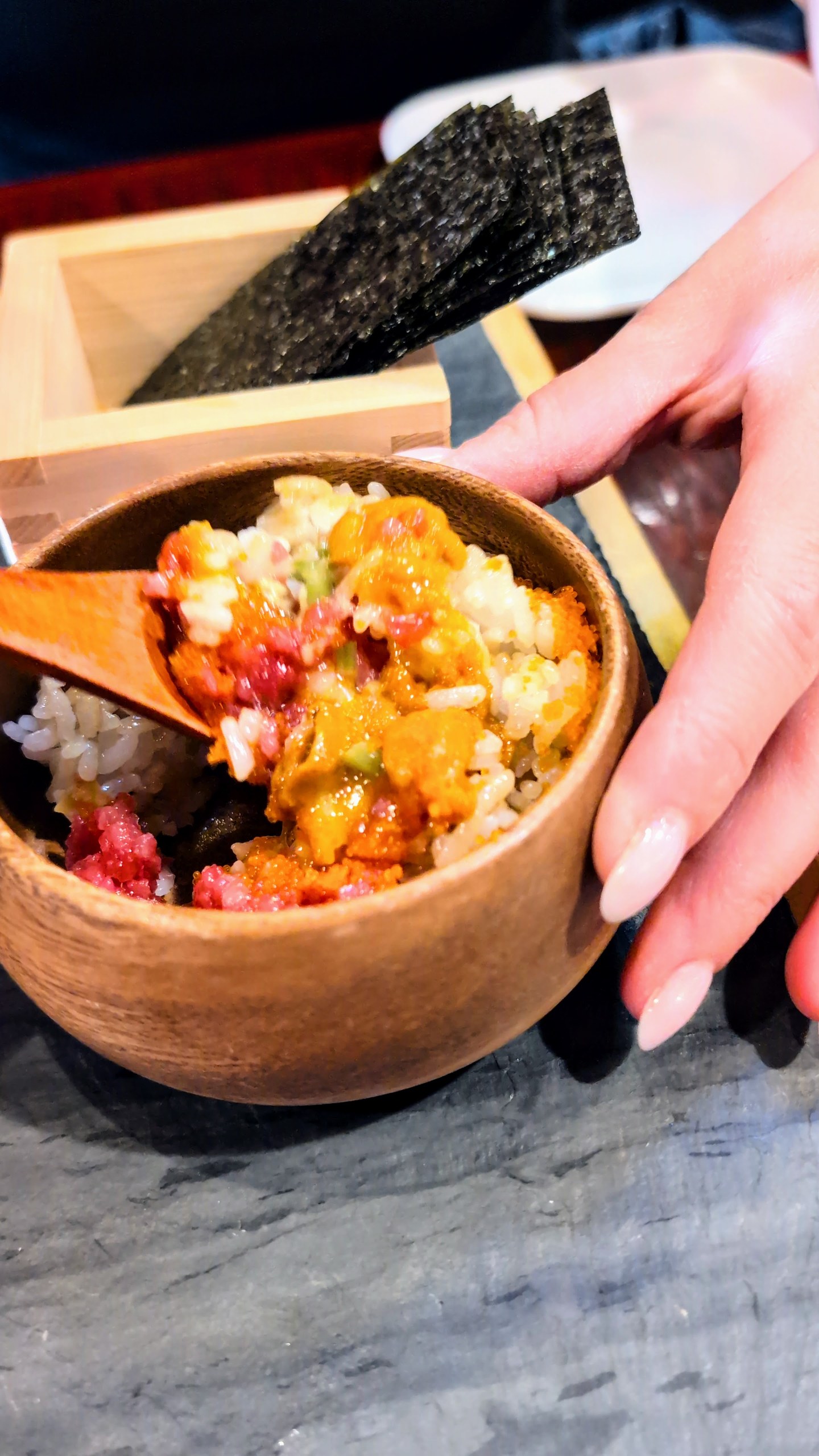 Unitoro Tartar after mixing, with uni visible on top and a wooden serving spoon resting in the bowl