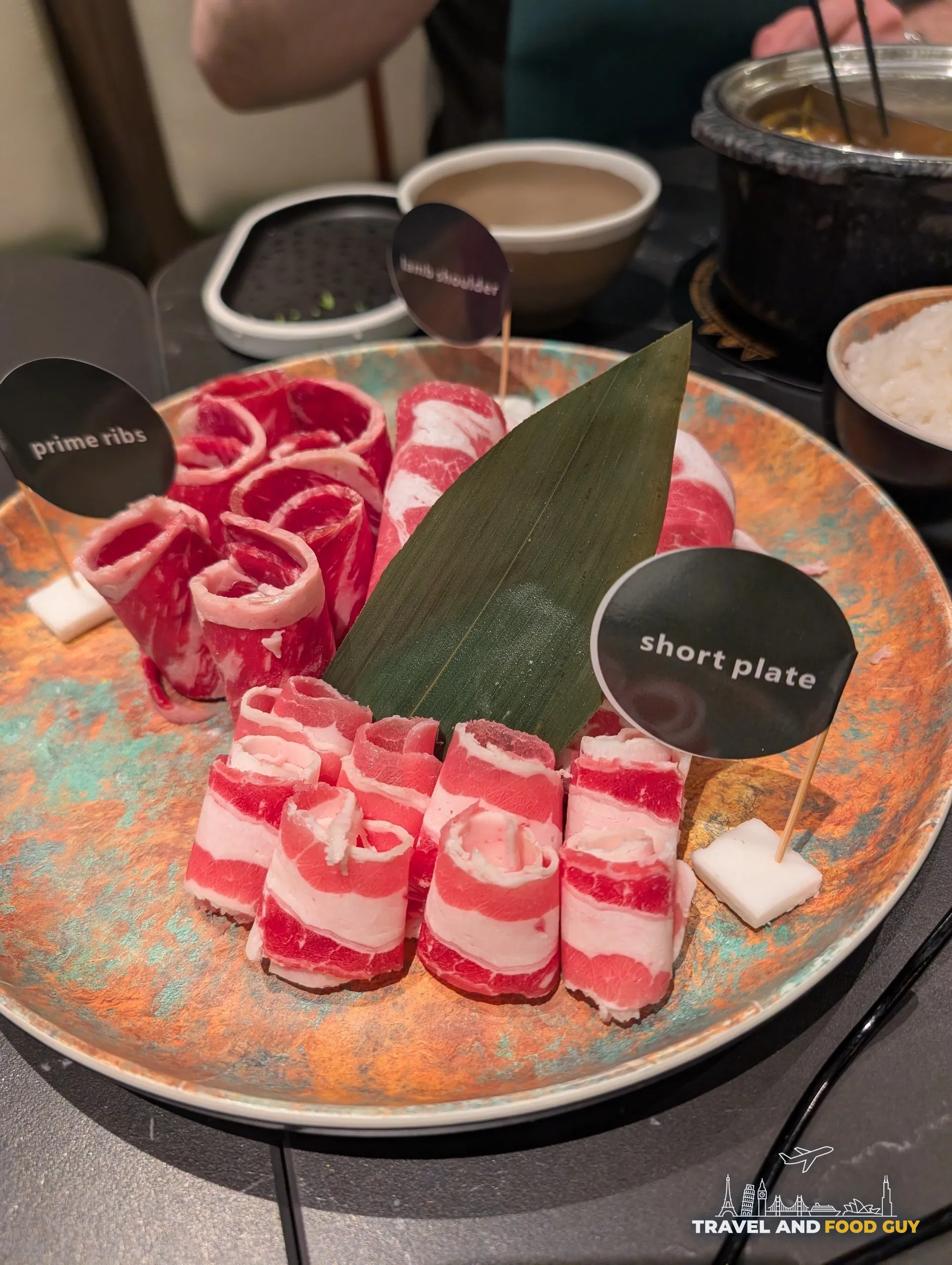 Hot pot meat platter at Broth and Beyond with labeled rolls of prime ribs, lamb shoulder, and short plate