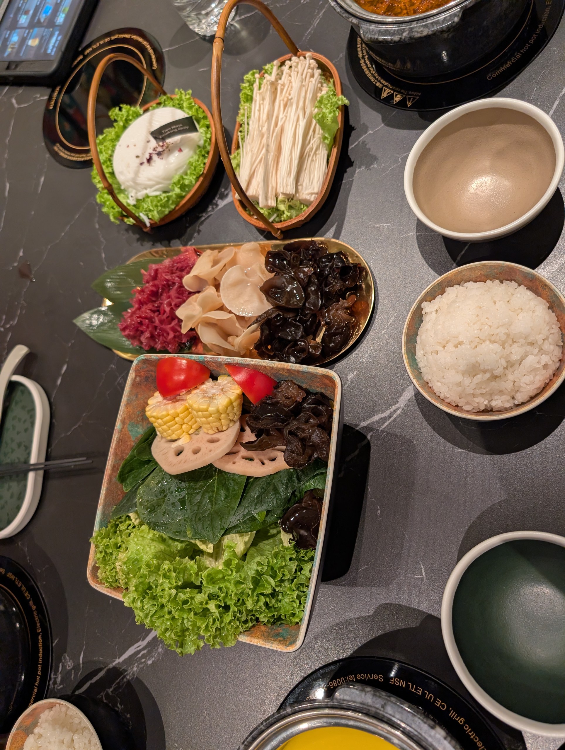 Overhead spread of enoki mushrooms, three-color cloud ear fungus, veggie basket and rice at Broth and Beyond