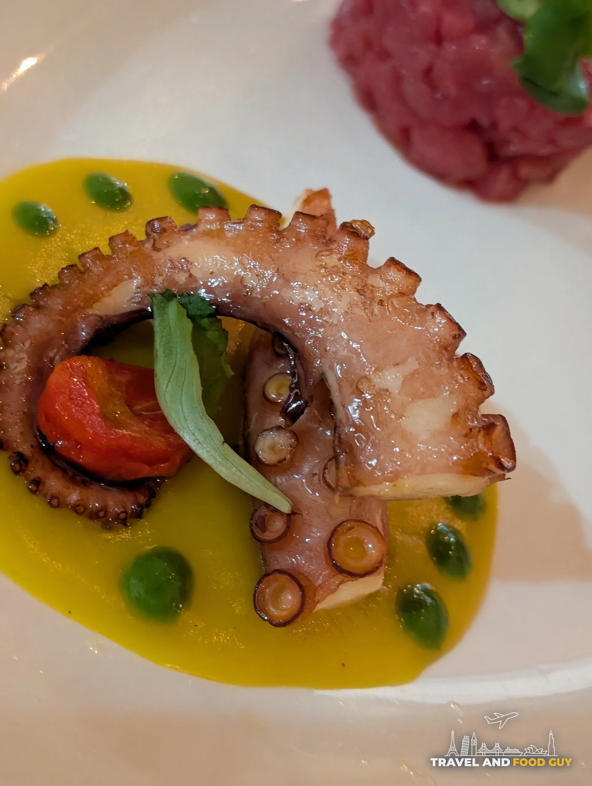 Grilled octopus tentacle on green pea sauce with cherry tomato and basil at Cantinetta delle Terme, Florence