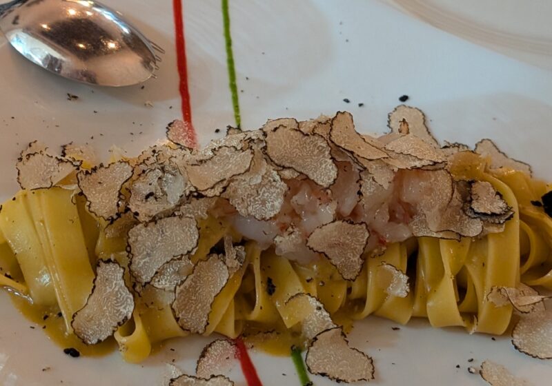 Fresh tagliatelle topped with generous shavings of white truffle, plated with red and green sauce dots in Italian-flag colors at Cantinetta delle Terme, Florence