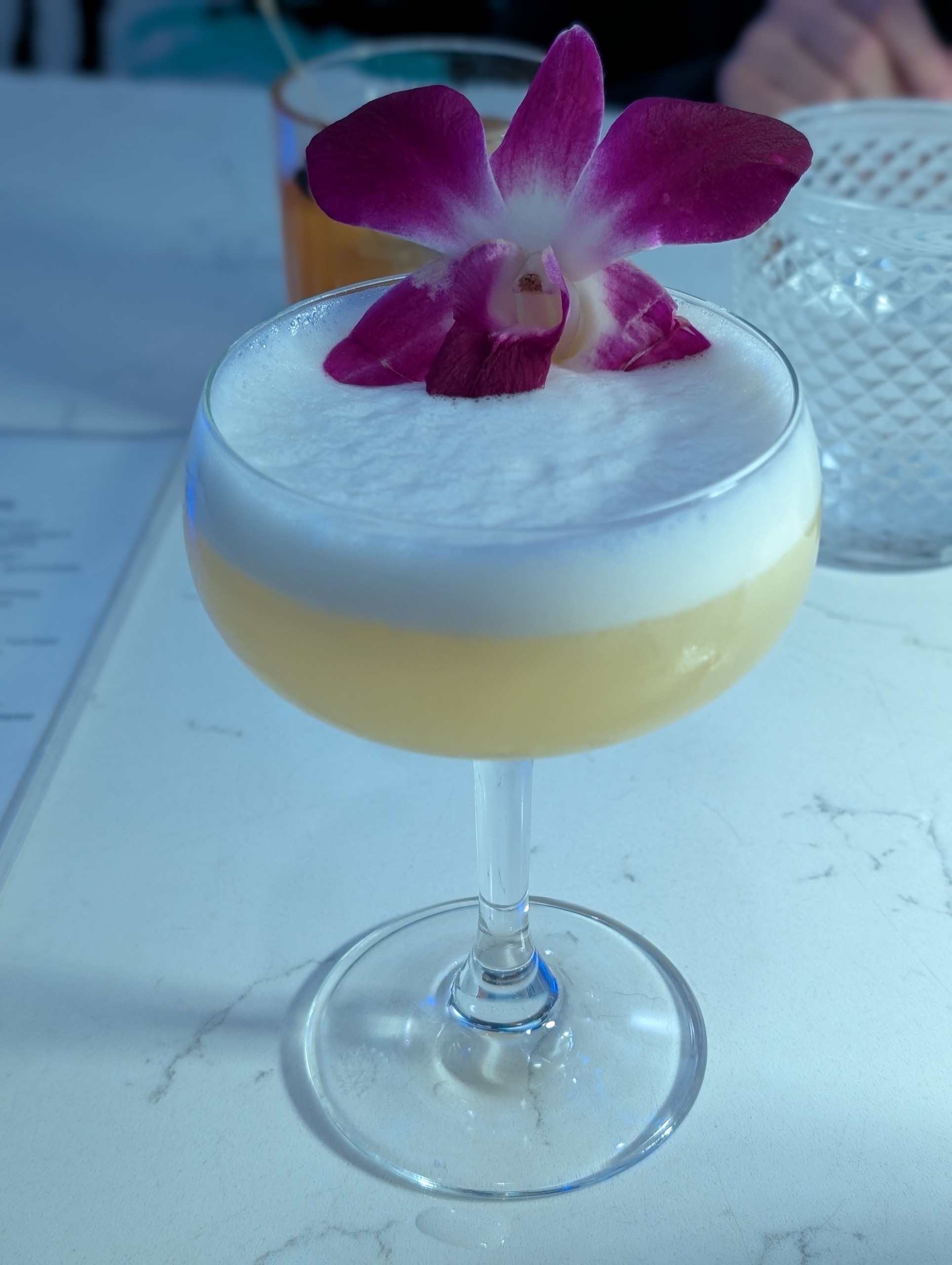 Full of Grace cocktail with orchid garnish at The Foxtail on the Lake