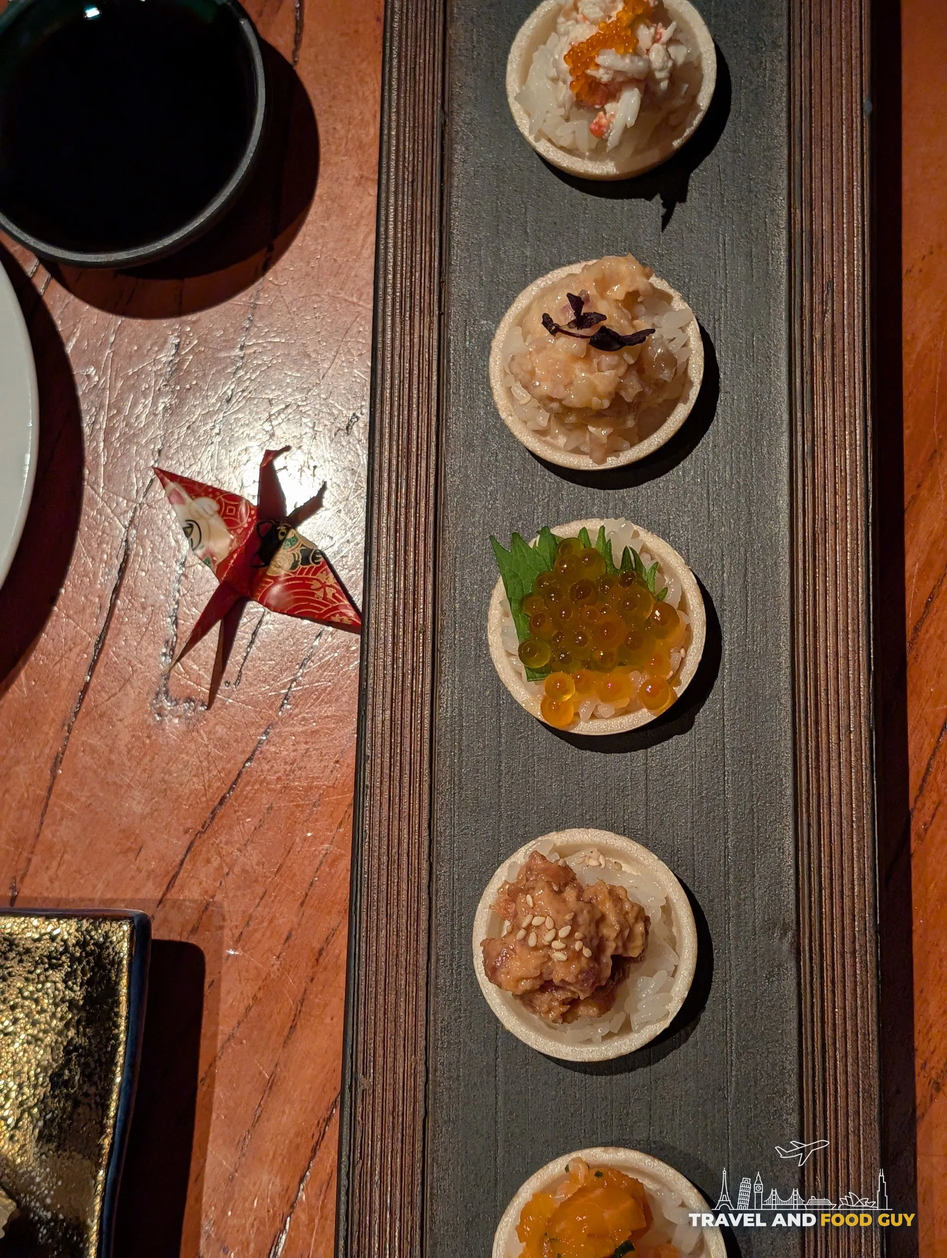 The six piece Monaka Sushi tasting board at KOMA Singapore, including ikura on shiso, salmon yuzu kosho, king crab cucumber, truffle unagi, spicy tuna, and spicy yellowtail.