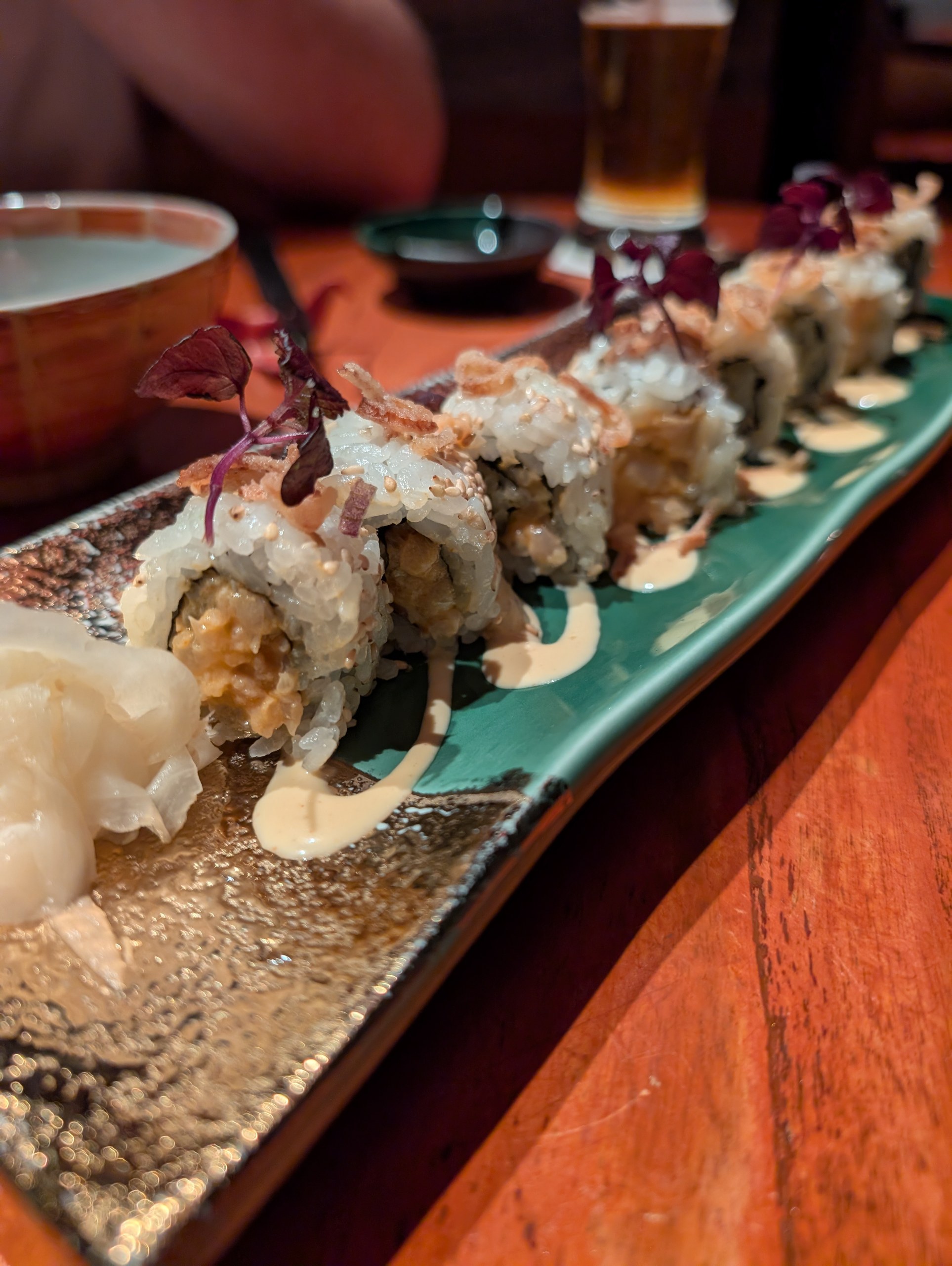 The Spicy Yellowtail maki roll at KOMA Singapore, topped with crispy fried shallots and spicy mayo.