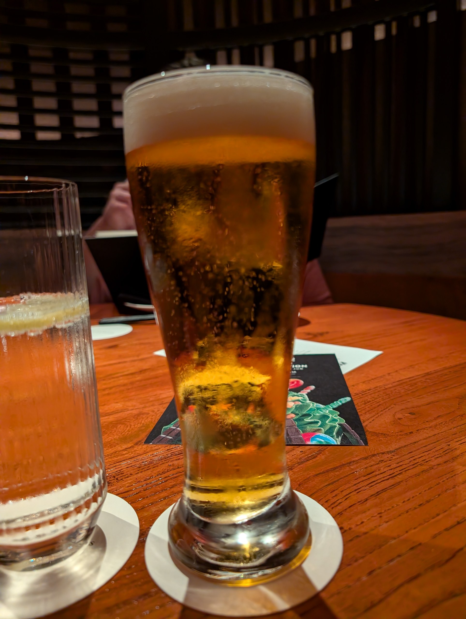 A tall pilsner glass of Suntory Premium Malt on draft next to a second glass of Master's Dream at KOMA Singapore.