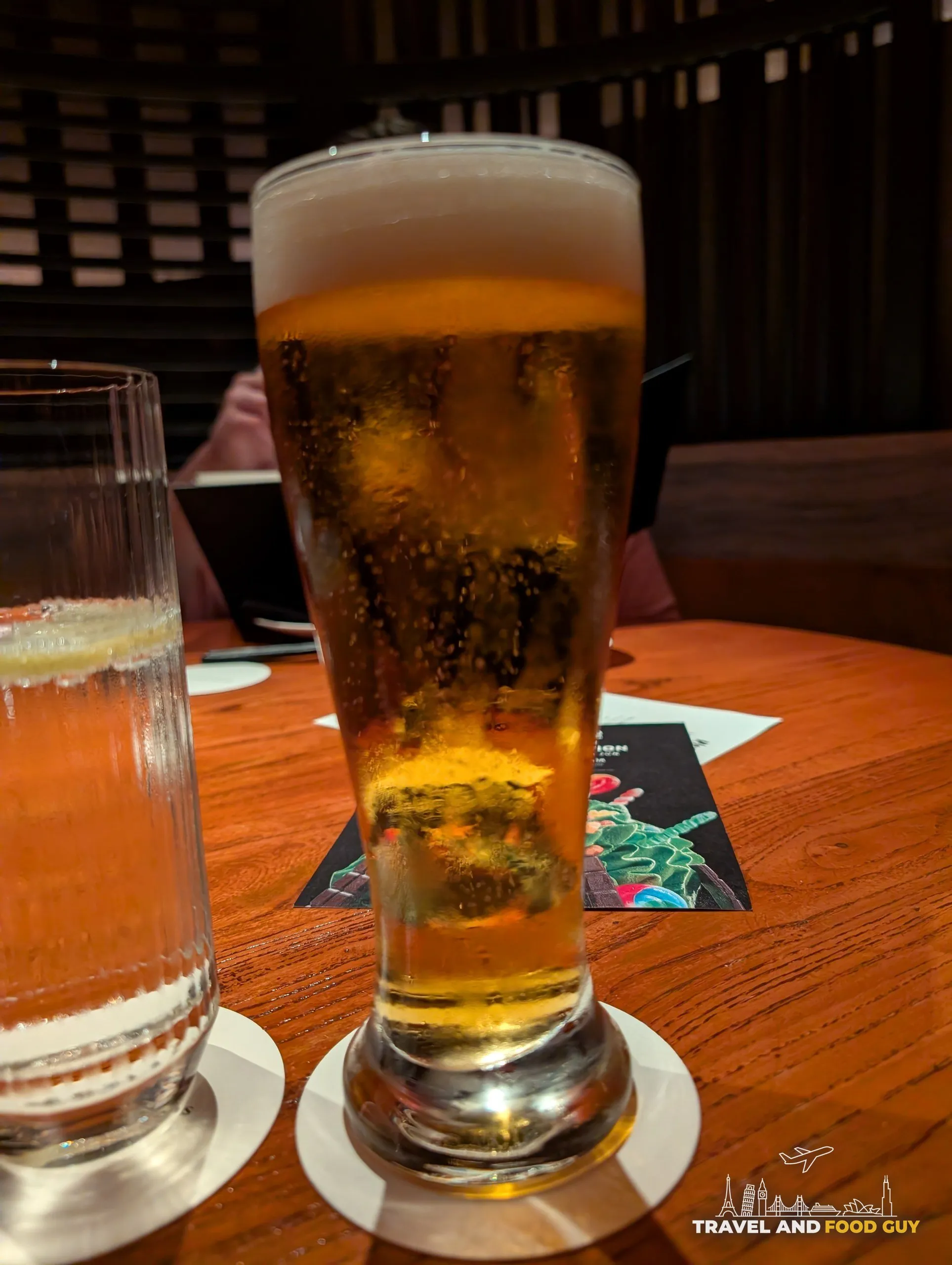 A tall pilsner glass of Suntory Premium Malt on draft next to a second glass of Master's Dream at KOMA Singapore.