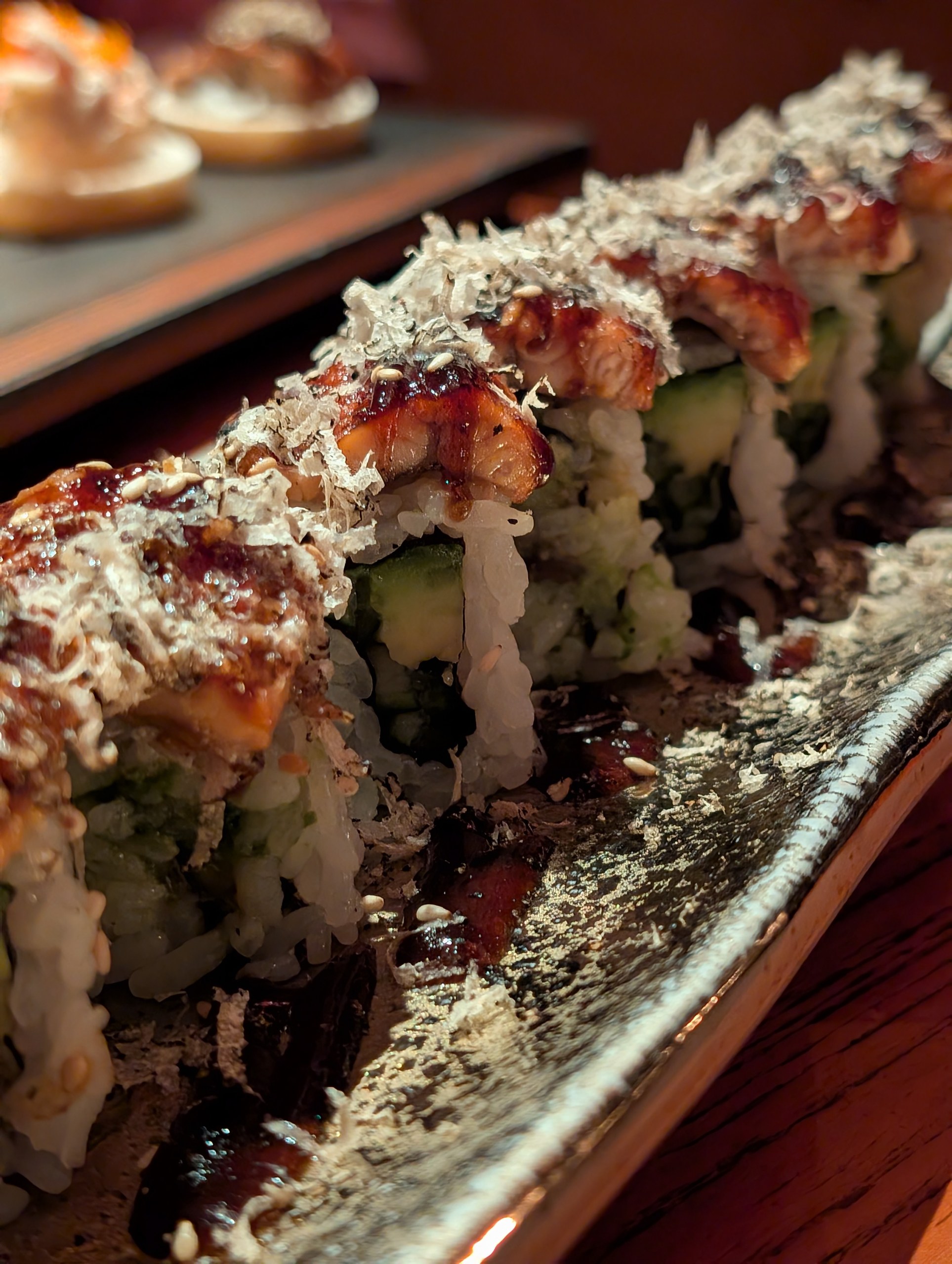 The Truffle Unagi roll at KOMA Singapore, glazed with sweet soy and topped with bonito flakes.