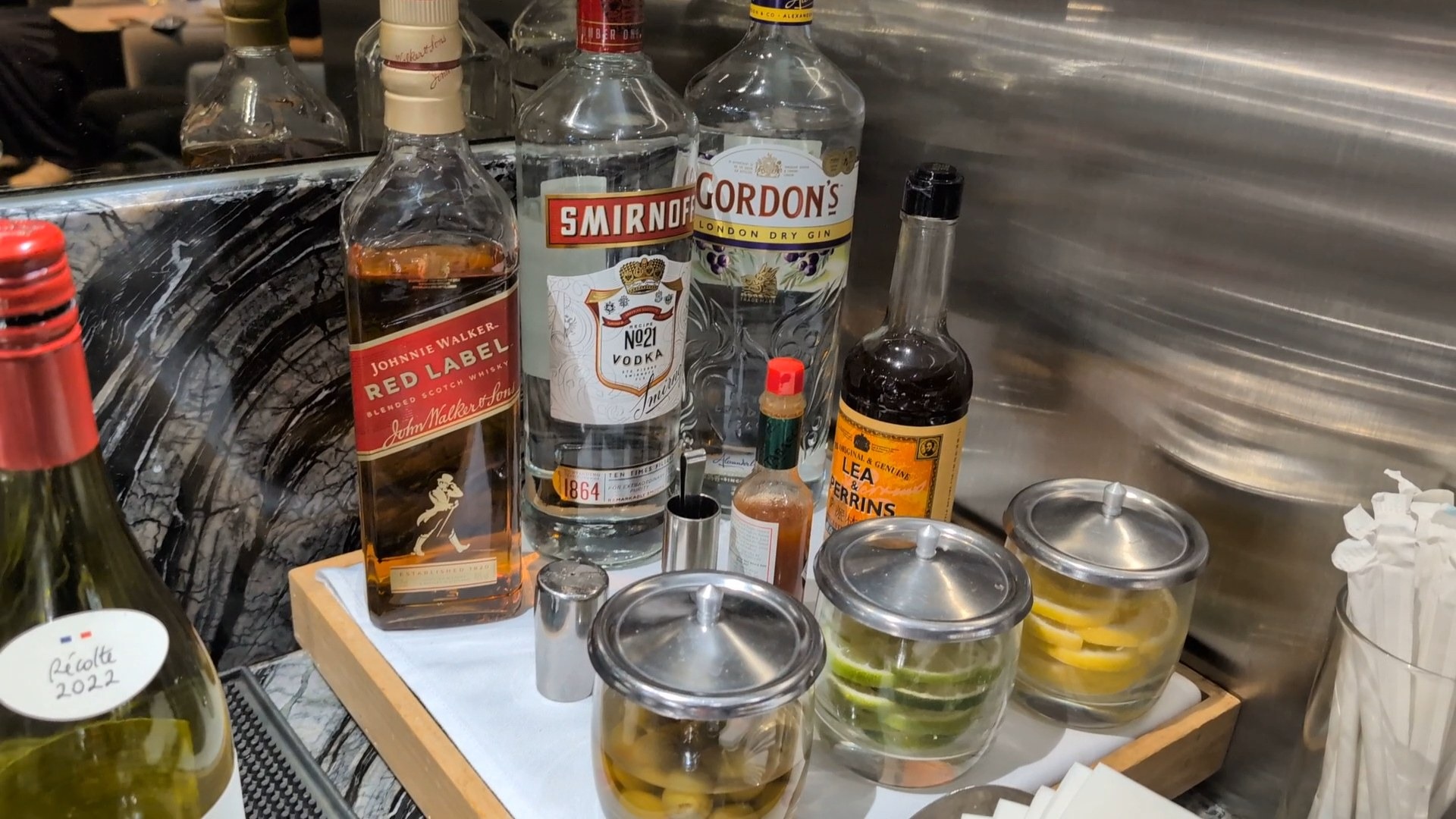 Self-pour spirit shelf with Johnnie Walker Red Label, Smirnoff No. 21 vodka, Gordon's London Dry Gin, and La Vieille Ferme white wine.