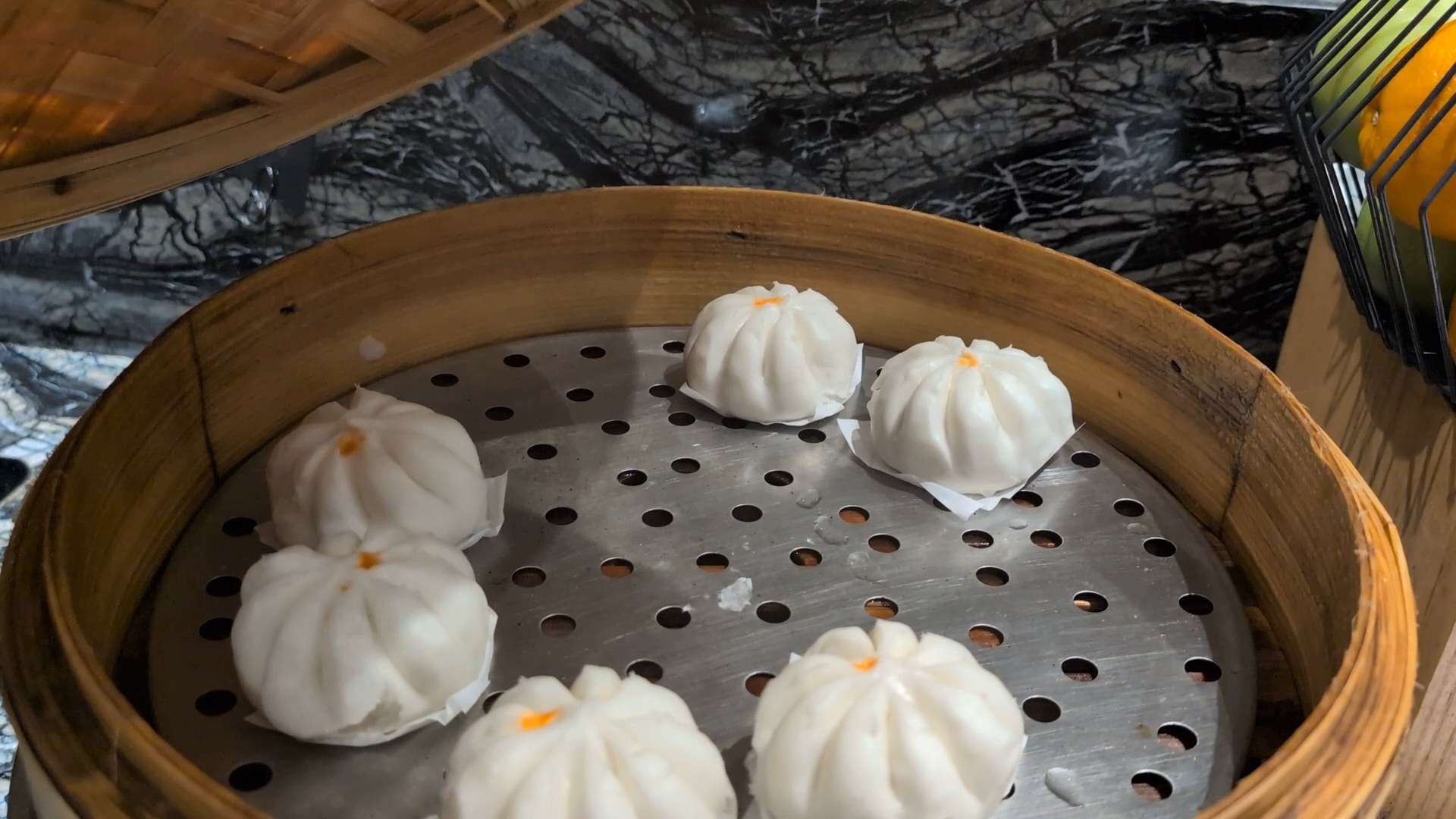 Steamed baos in a bamboo steamer at the KrisFlyer Gold Lounge dim sum line.