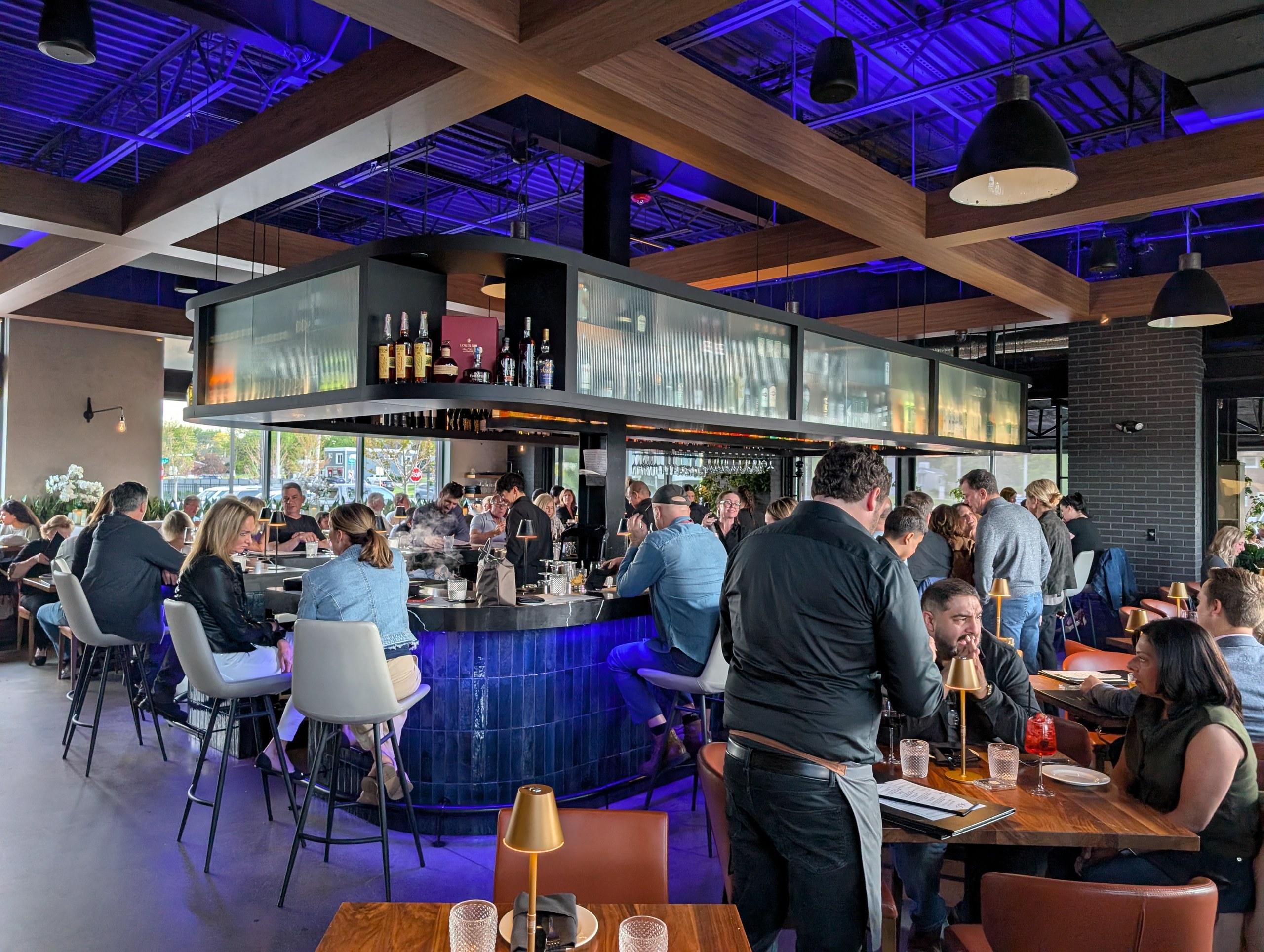 The signature blue tile bar at LAGO Lake Zurich with bottles displayed above