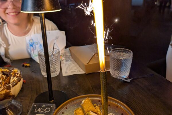 Cannoli with a giant sparkler arriving at the table for an early Mother's Day at LAGO Lake Zurich, Emily smiling in the background