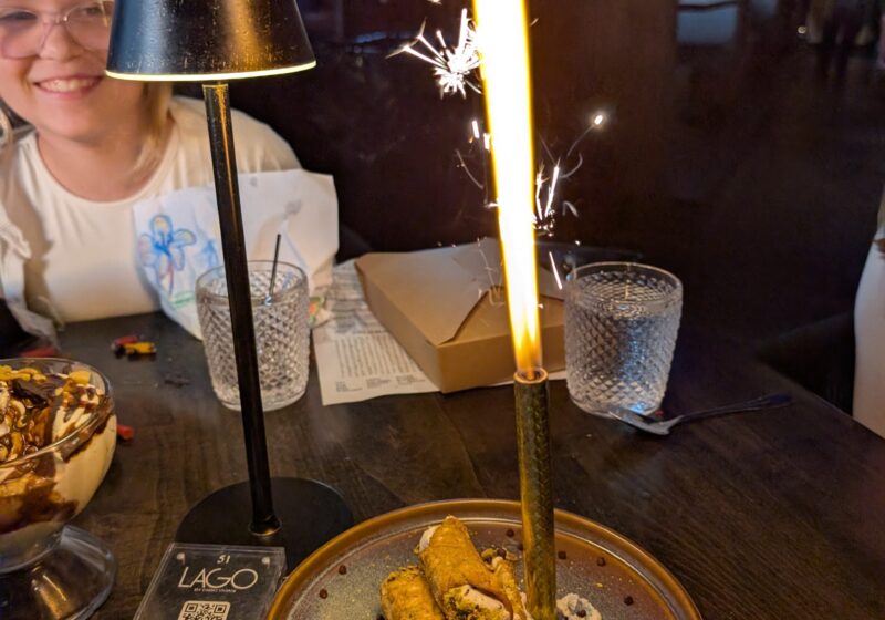 Cannoli with a giant sparkler arriving at the table for an early Mother's Day at LAGO Lake Zurich, Emily smiling in the background