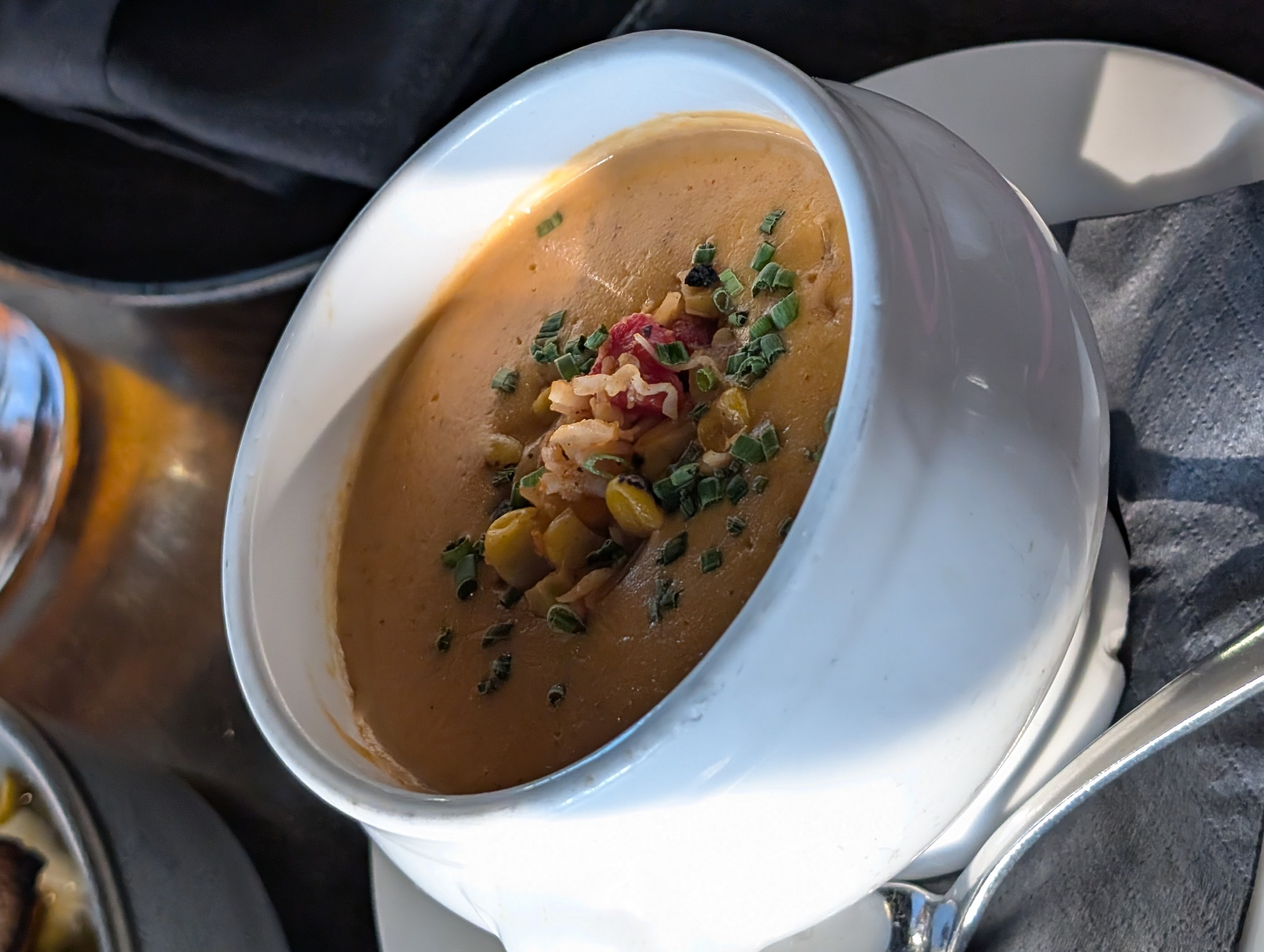 Creamy Maine Lobster Bisque at LAGO Lake Zurich with chunks of lobster meat, sweet corn, and chives