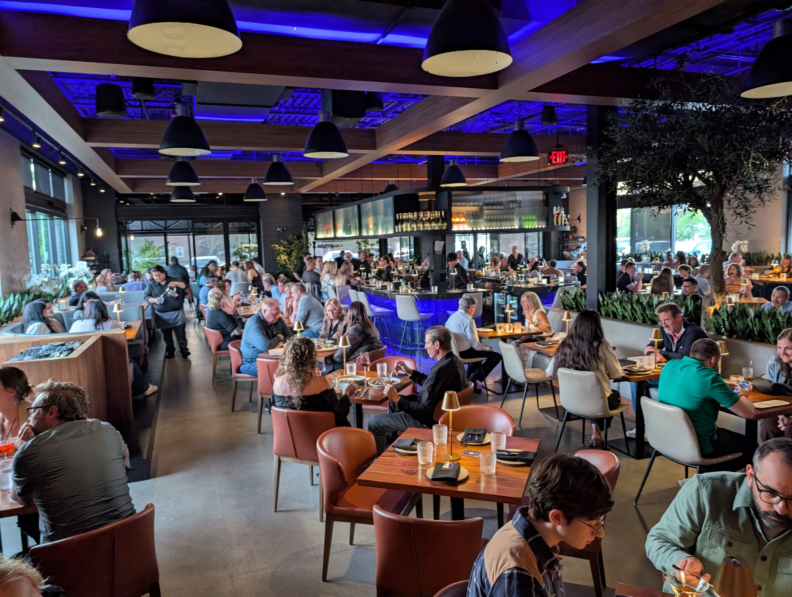 Wide view of the LAGO Lake Zurich dining room with blue accent ceiling and curved bar