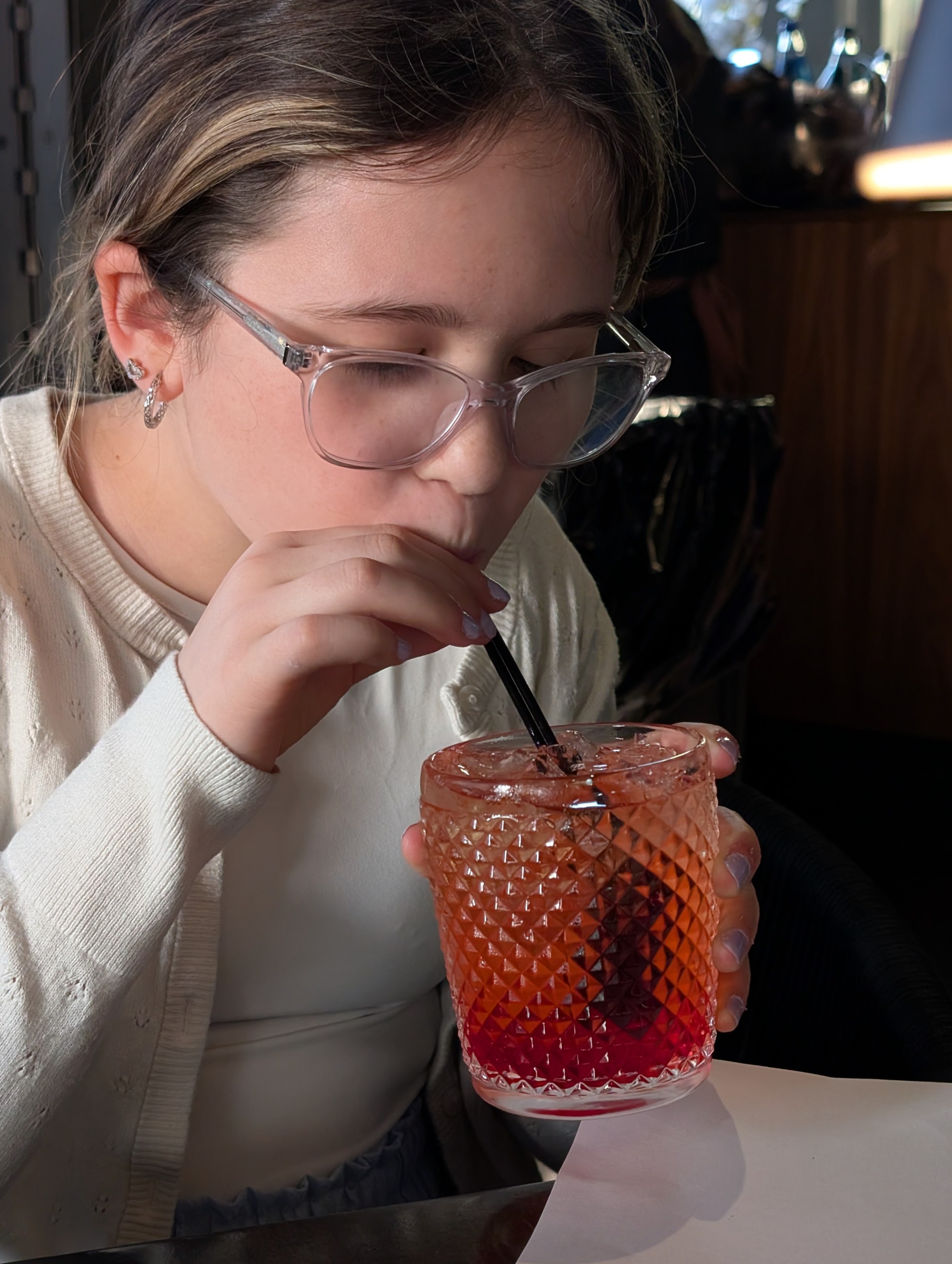 Emily holding a Carousel mocktail in a diamond cut crystal glass at LAGO Lake Zurich