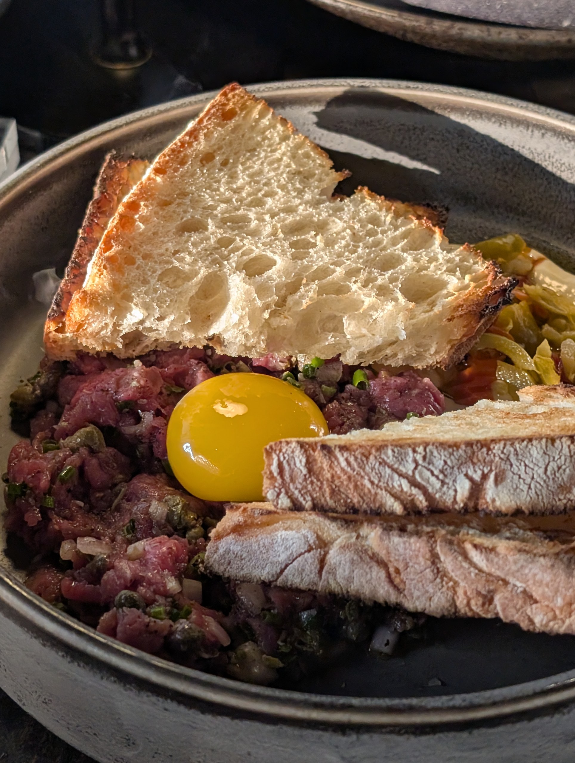 Smoked Filet Mignon Tartare at LAGO Lake Zurich with a bright orange farm egg yolk on top and grilled sourdough alongside