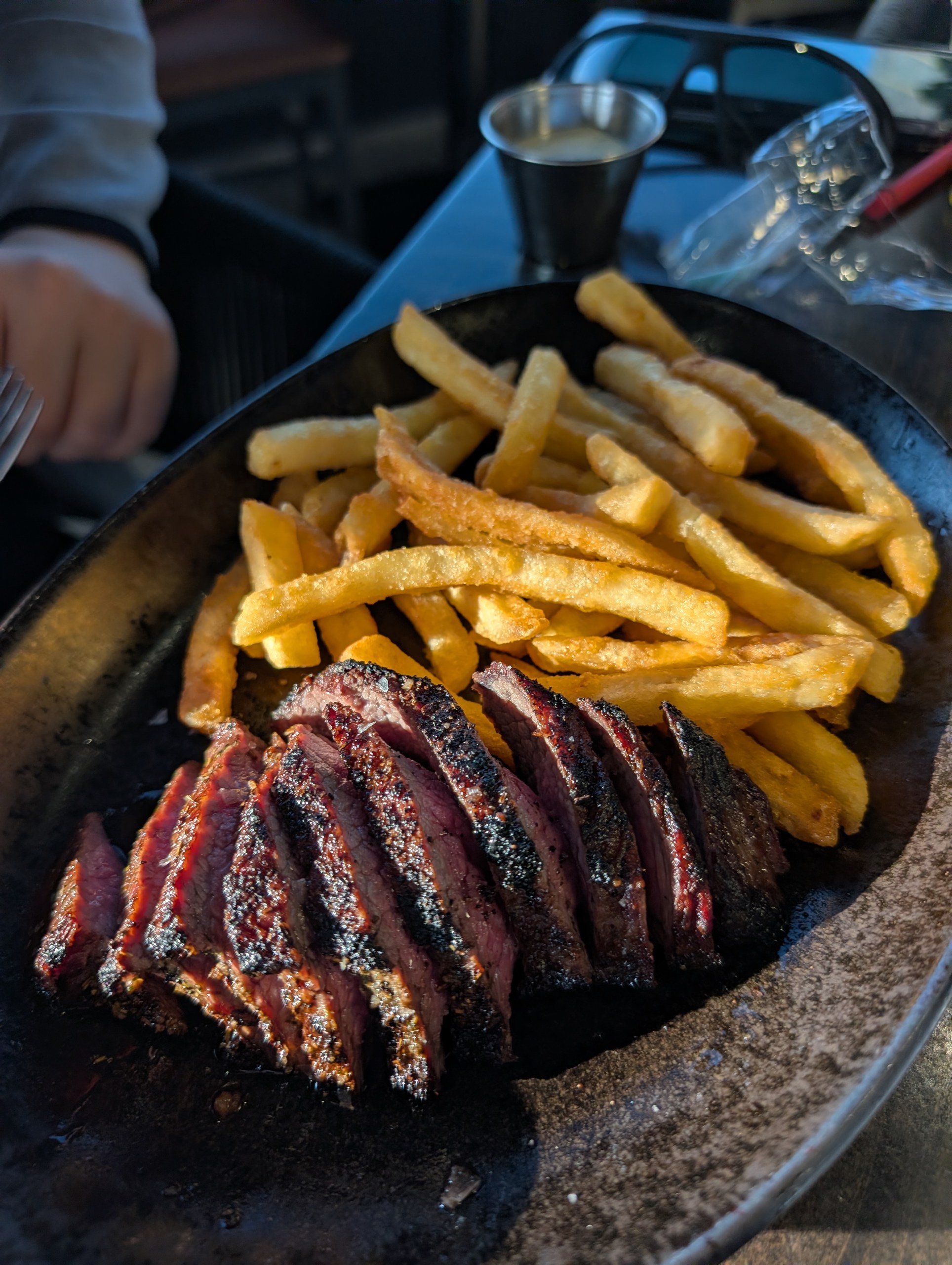 Sliced pepper crusted Steak Frites with golden fries at LAGO Lake Zurich