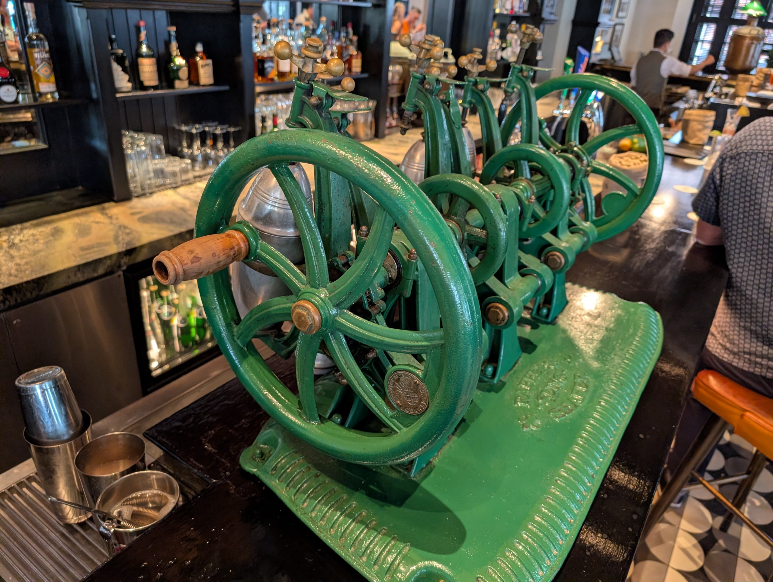 Row of vintage green iron hand-crank cocktail shakers at Long Bar, Raffles Hotel Singapore