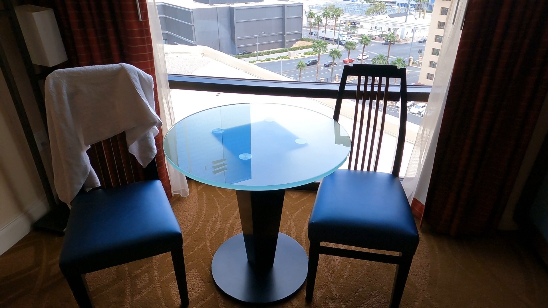 Bistro table and chairs at the window of the Marriott Grand Chateau two-bedroom suite with a Las Vegas Strip view