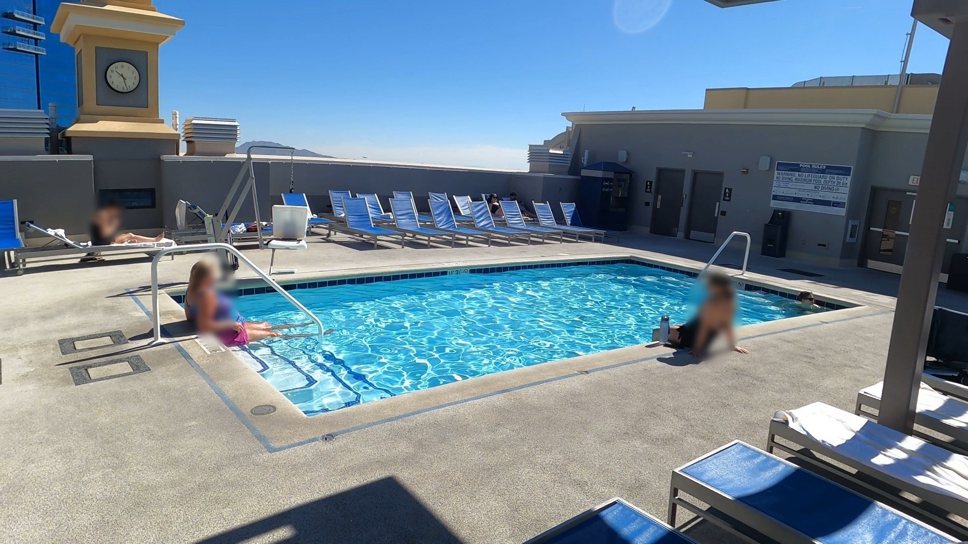 Upper pool at the Marriott Grand Chateau Las Vegas with kids swimming and blue lounge chairs