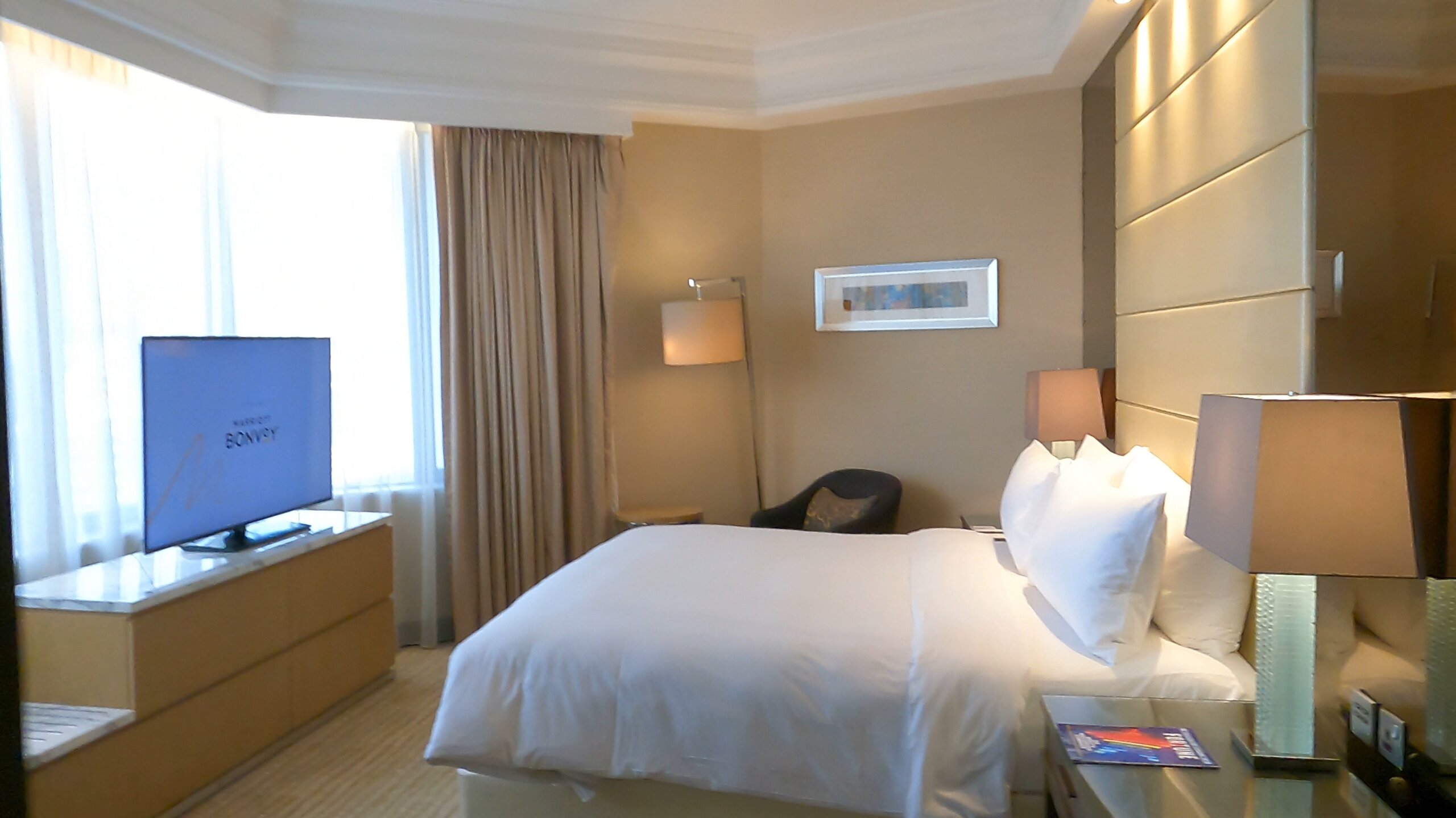 Executive Suite bedroom with Bonvoy welcome screen on TV at the Singapore Marriott Tang Plaza