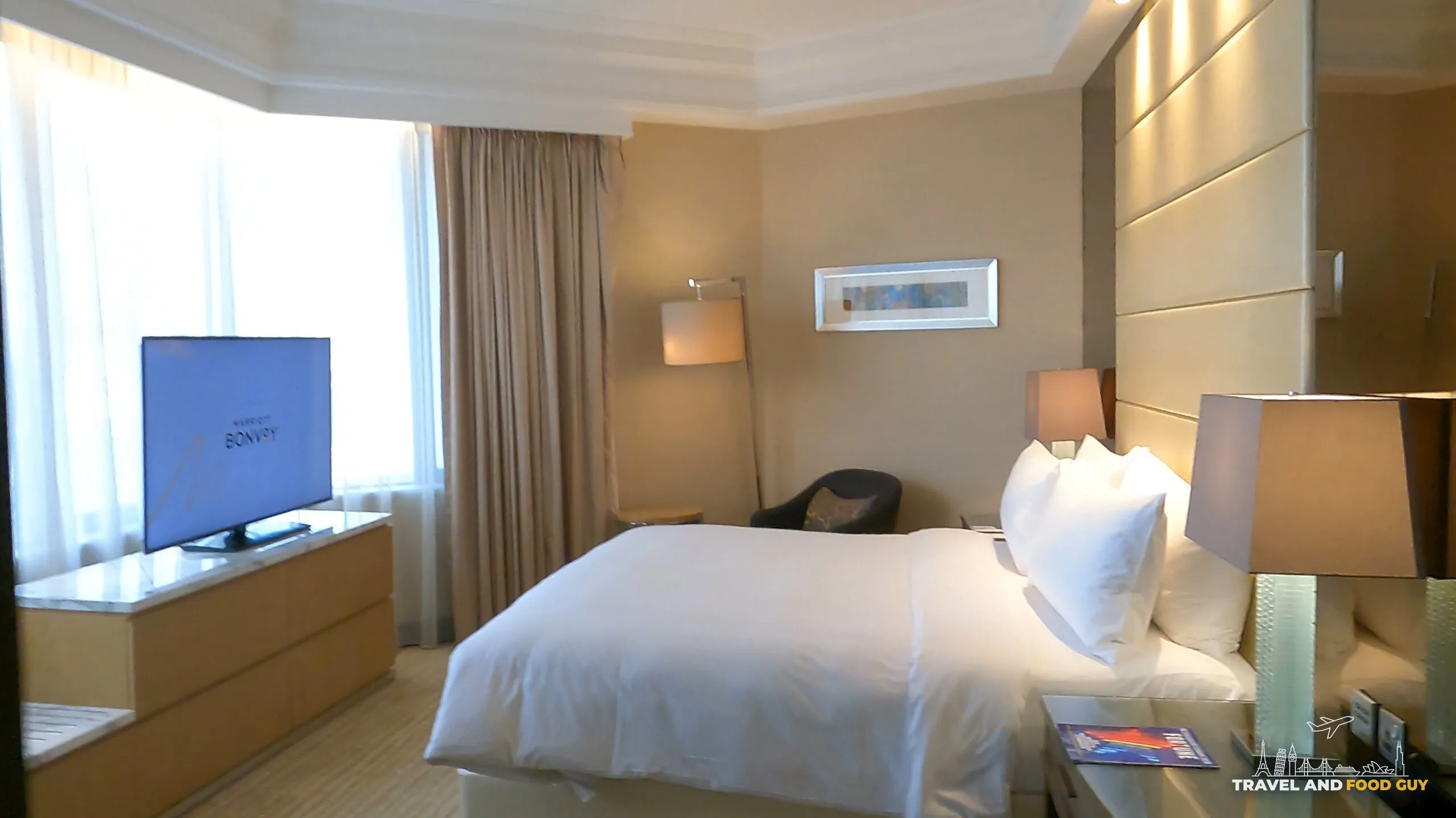 Executive Suite bedroom with Bonvoy welcome screen on TV at the Singapore Marriott Tang Plaza