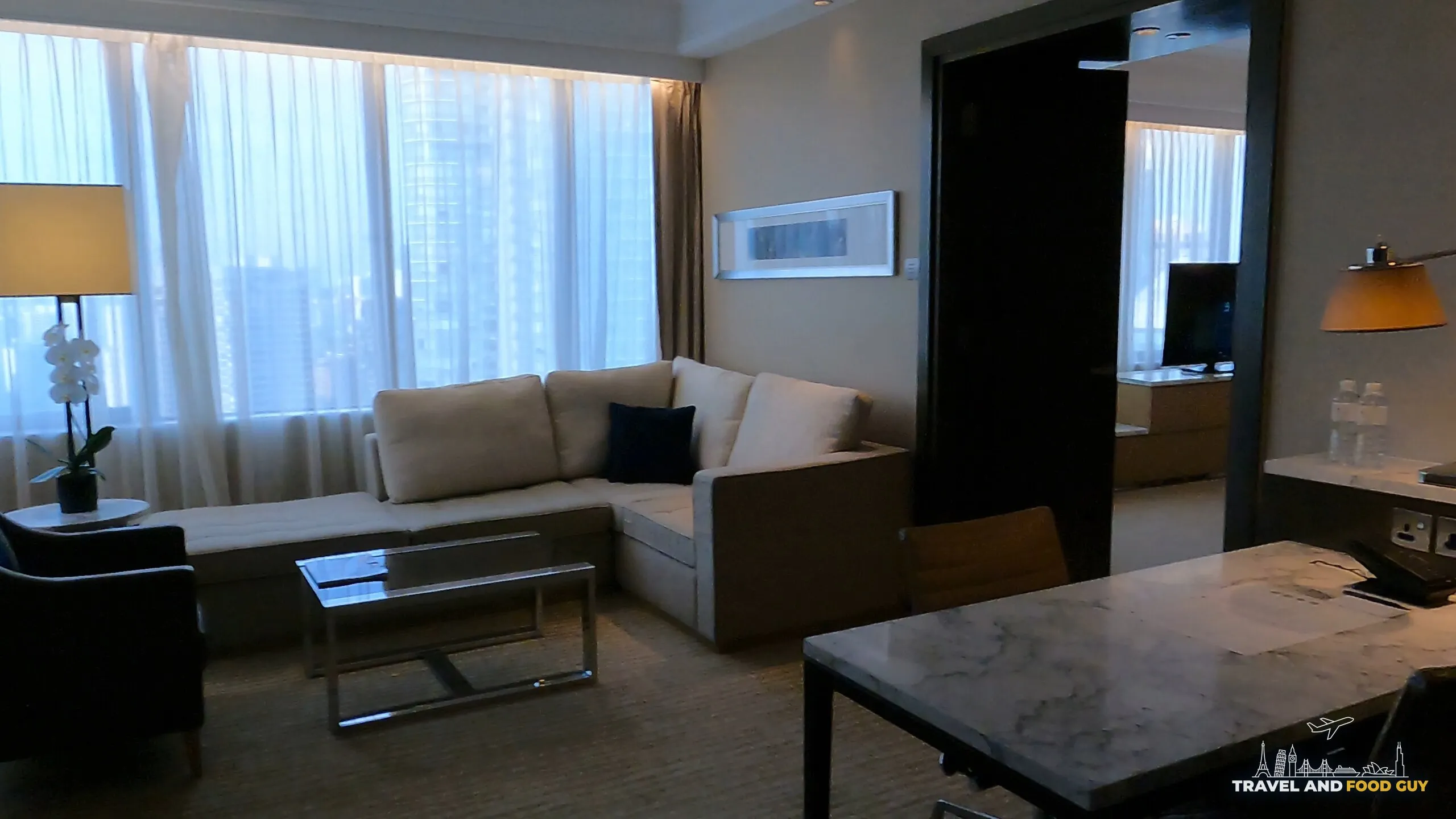Executive Suite living room with sectional sofa and marble dining table at the Singapore Marriott Tang Plaza