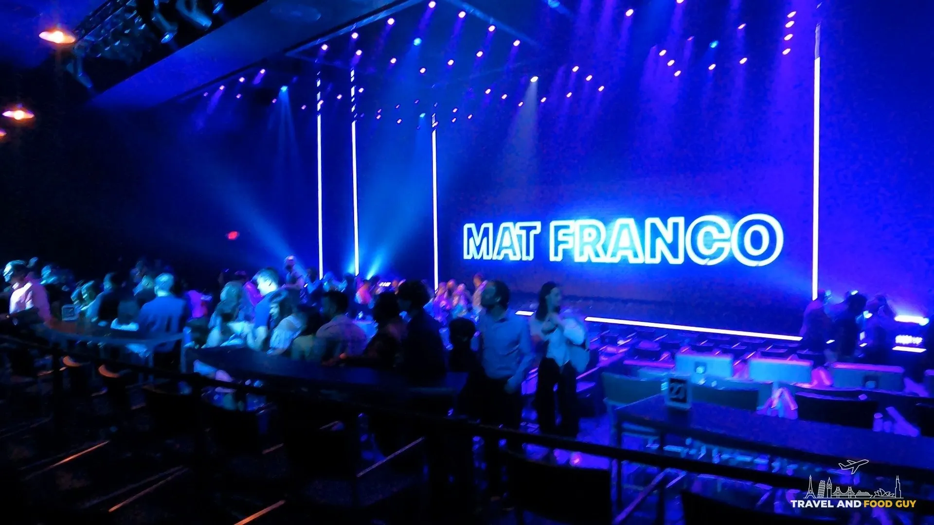 Wide view of the Mat Franco theater at The Linq with the Mat Franco neon sign on stage and the audience filing in