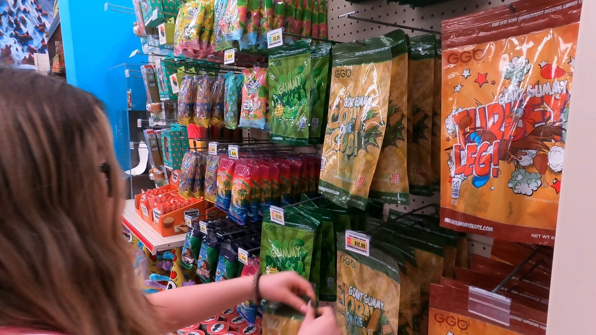 Emily browsing the giant gummy turkey leg and gummy corn cob shelf at Omega Mart