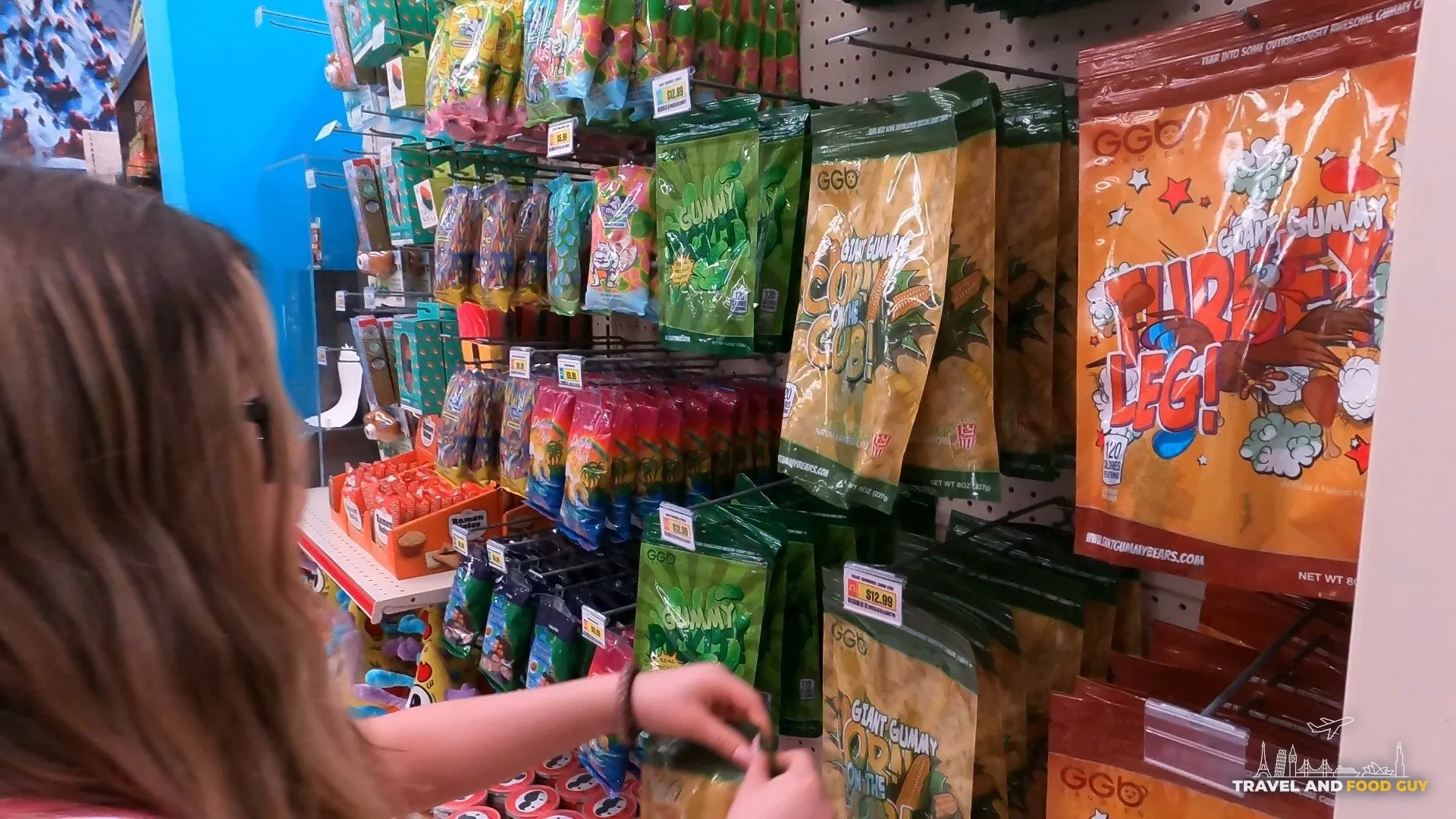 Emily browsing the giant gummy turkey leg and gummy corn cob shelf at Omega Mart