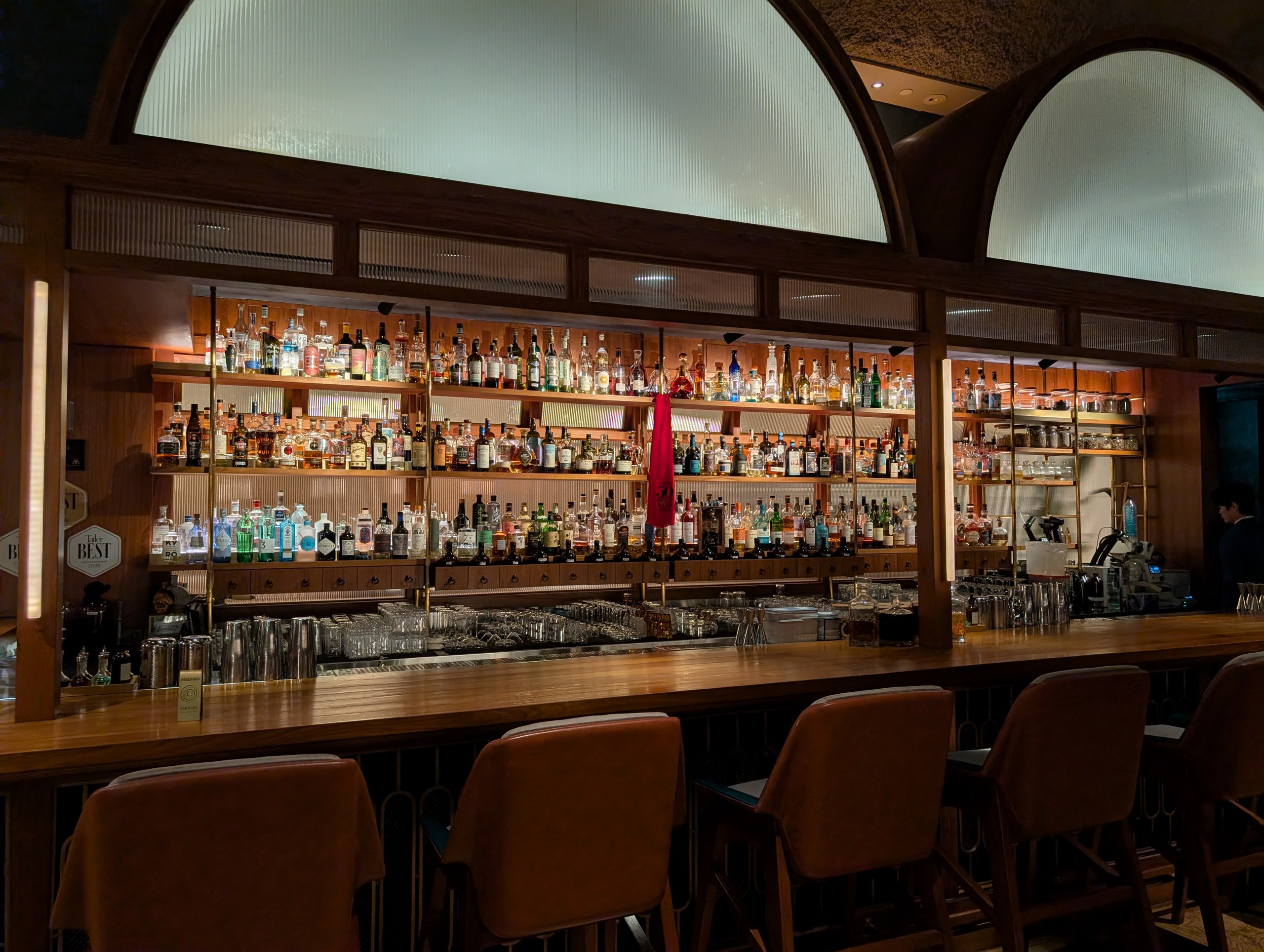 The back bar at Origin Grill and Bar, lined with the spirit collection that backs the cocktail menu.
