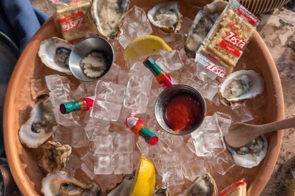 A dozen east coast oysters on a clay platter of ice with lemon wedges, hot sauce and crackers at Ostras Lounge in Des Plaines.